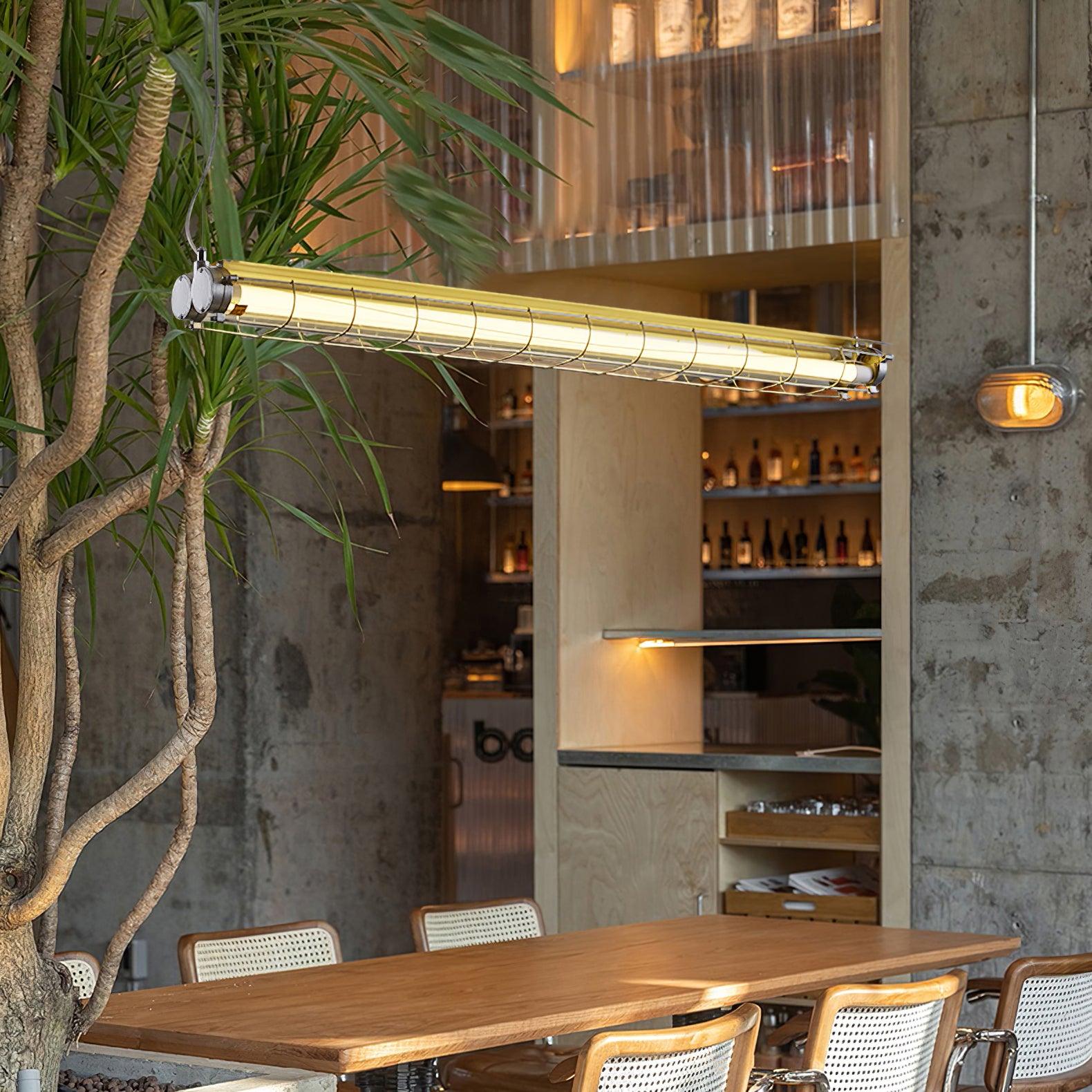 Artisan Glass chandelier above a wooden counter beside a tree and bottle shelves