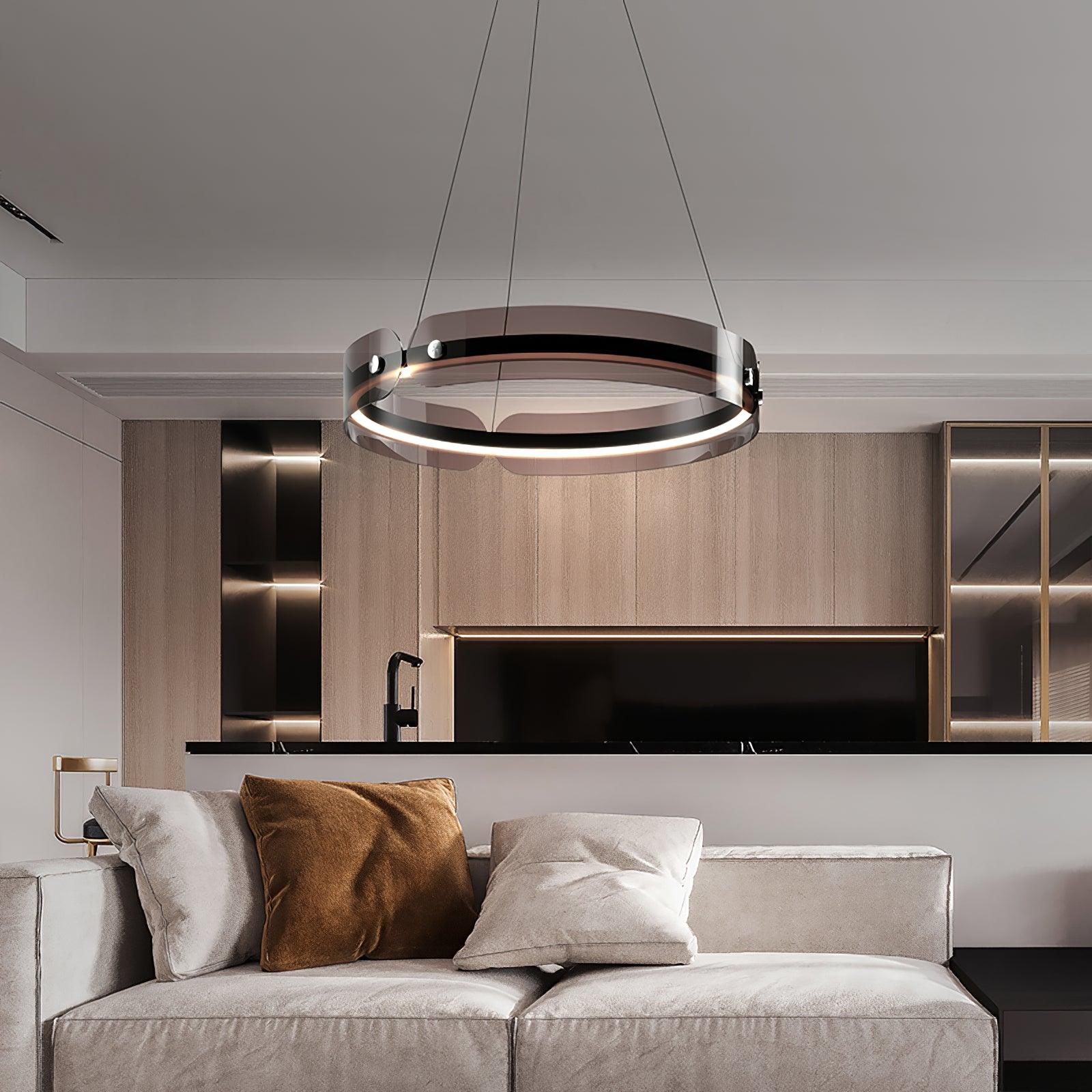 Javor black and coffee ring chandelier above a pale sofa with white and brown cushions beside a light kitchen