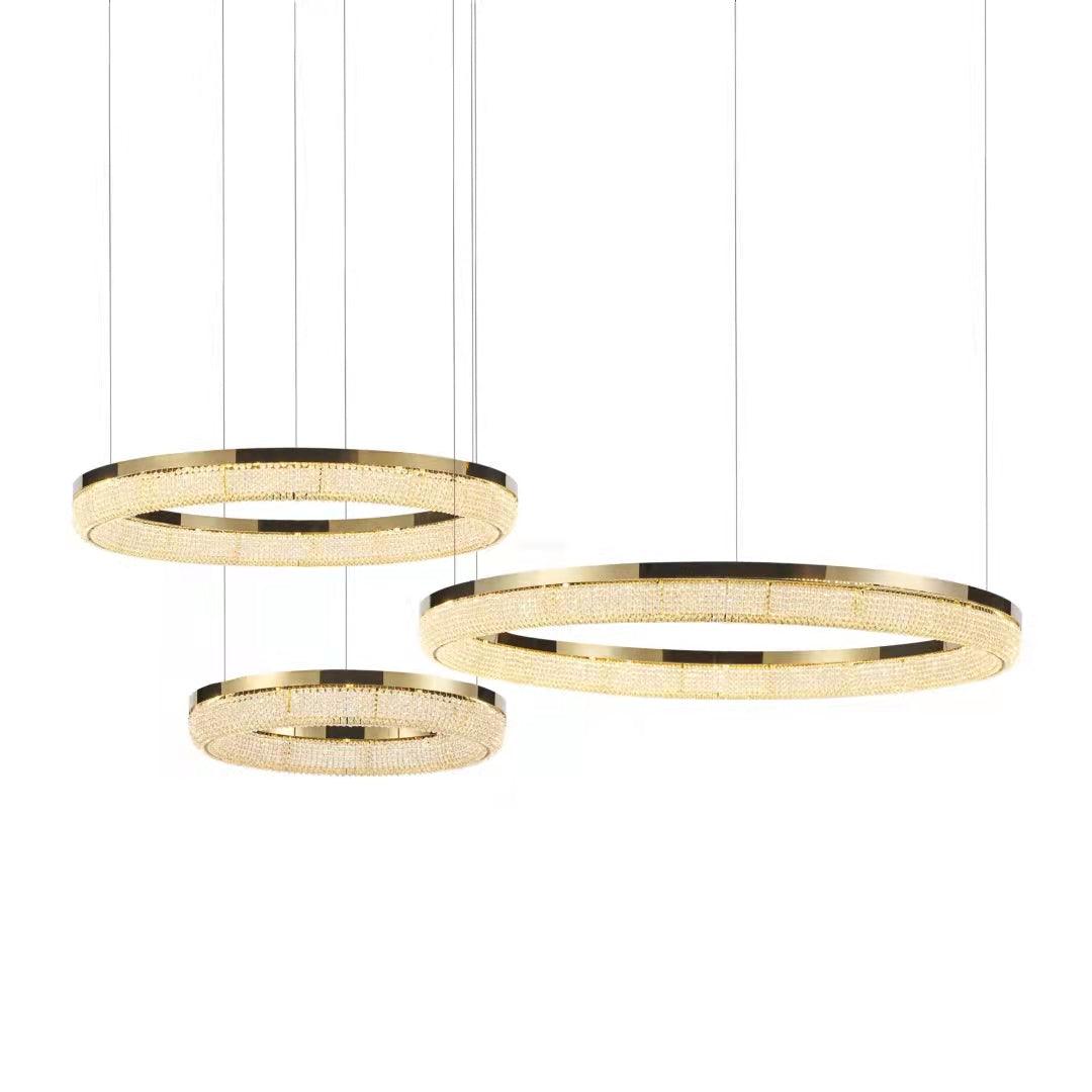 Offset composition of three illuminated gold crystal rings suspended at different heights