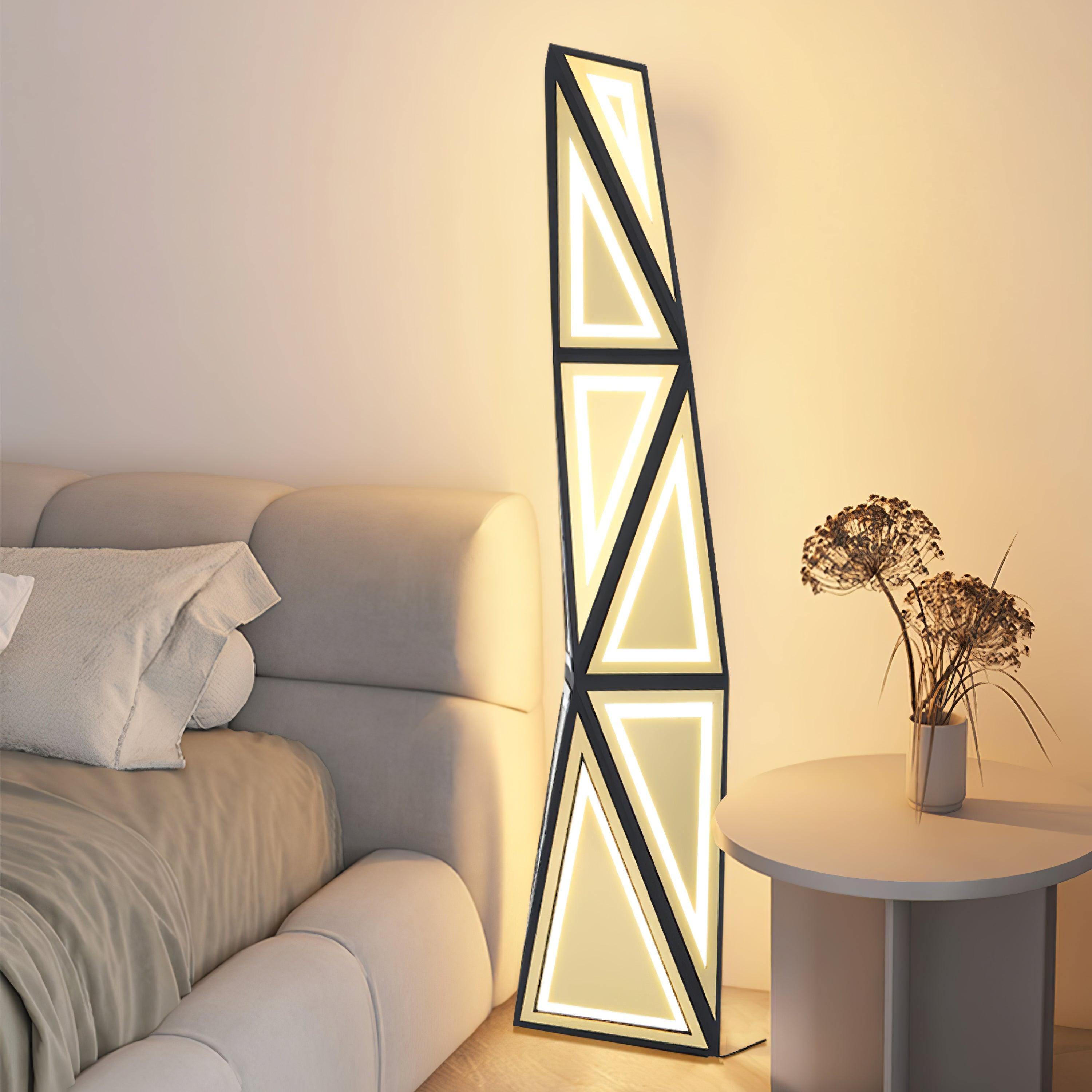 Angular LED floor lamp beside a cream sofa and white side table with dried flowers