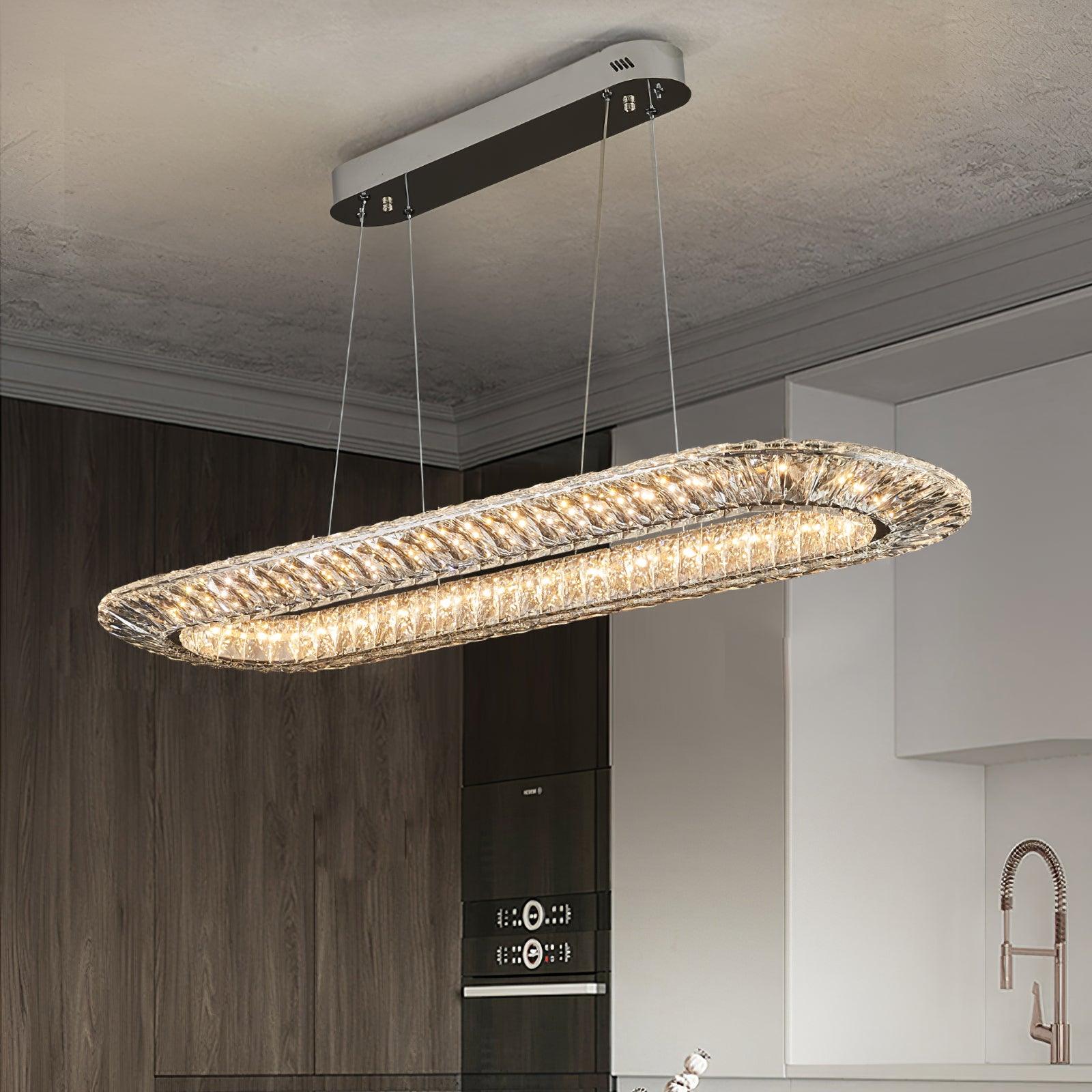 Elongated crystal chandelier above an island