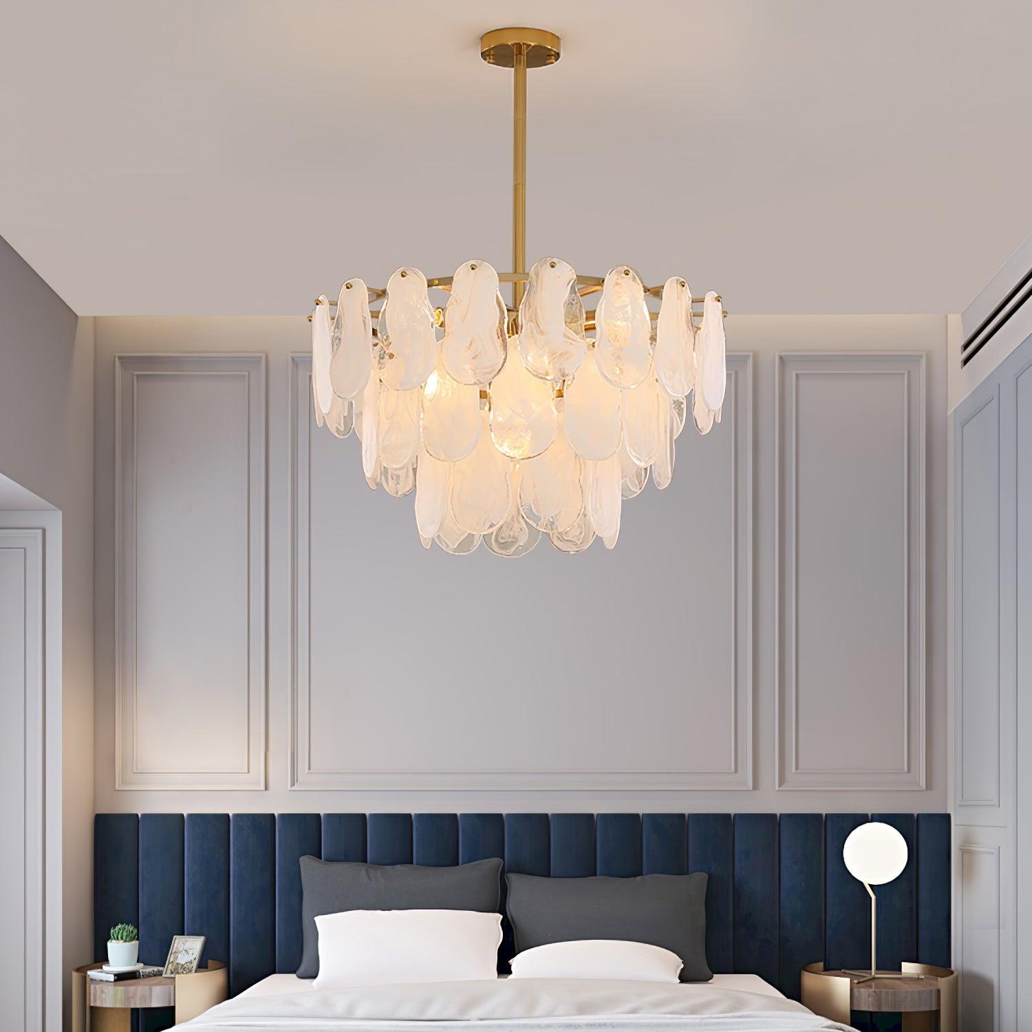Round Cloud glass pendant suspended above a bed with a dark blue headboard