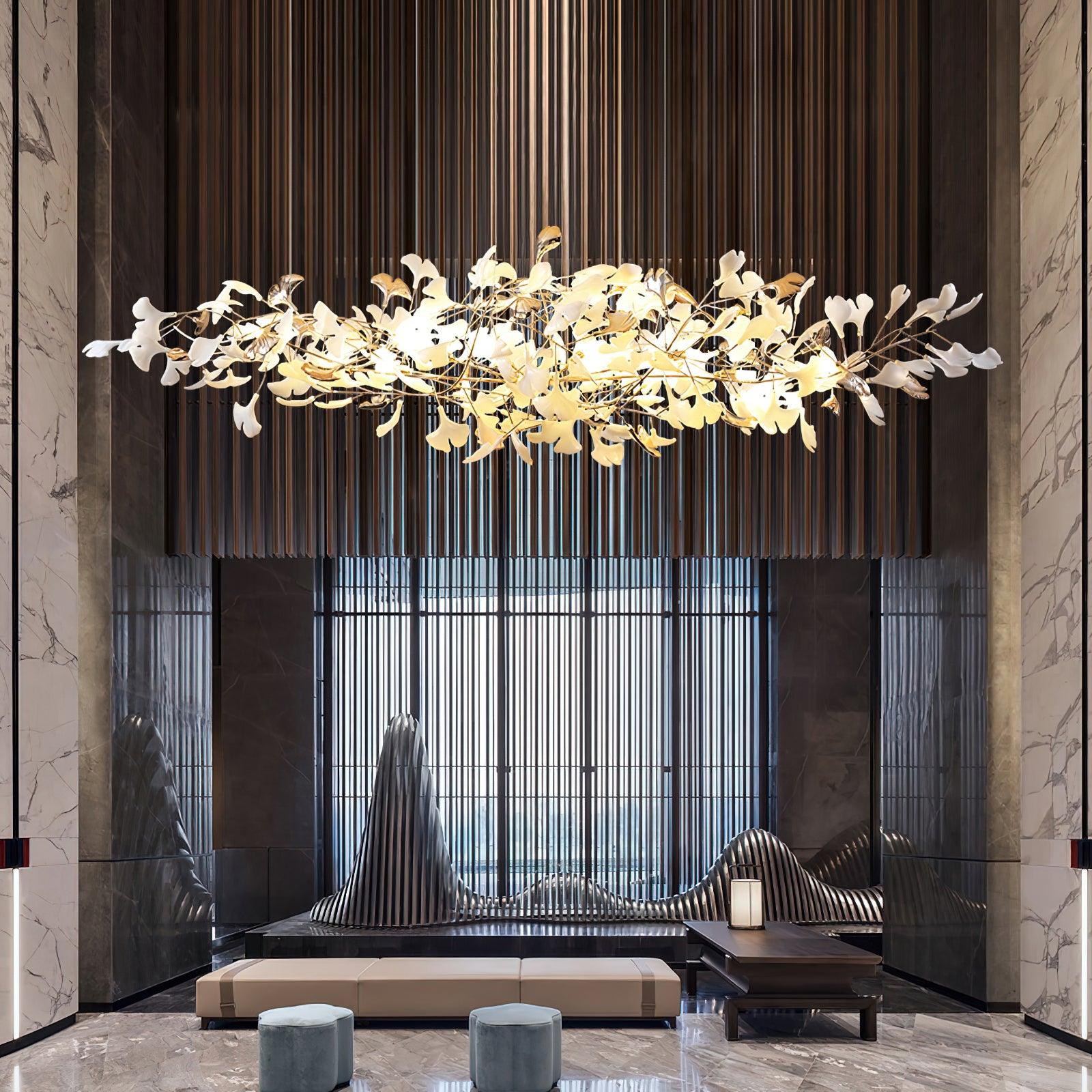 Glowing leaf chandelier in marble lounge above pale bench and blue stools, with vertical wooden slats behind