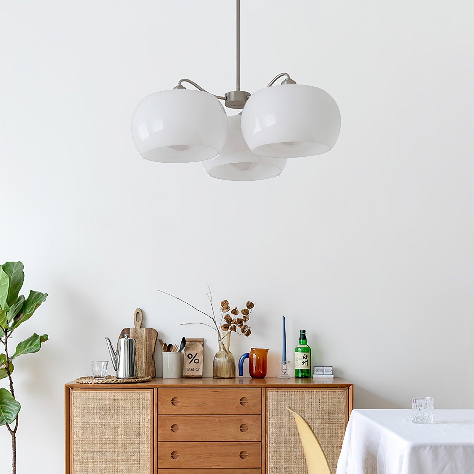 Persimmon chandelier with white glass shades and curved nickel-tone arms