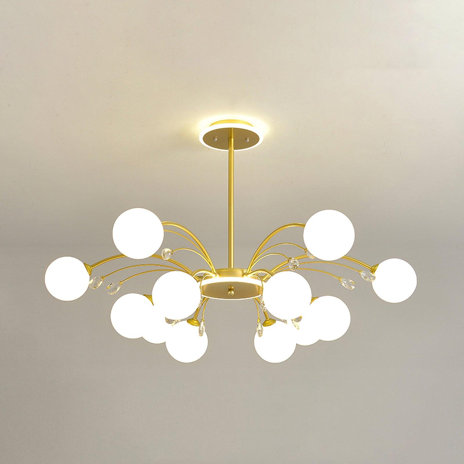 Twelve-light Gold version with paired front globes, clear drops and curved arms, listed at 100 cm diameter