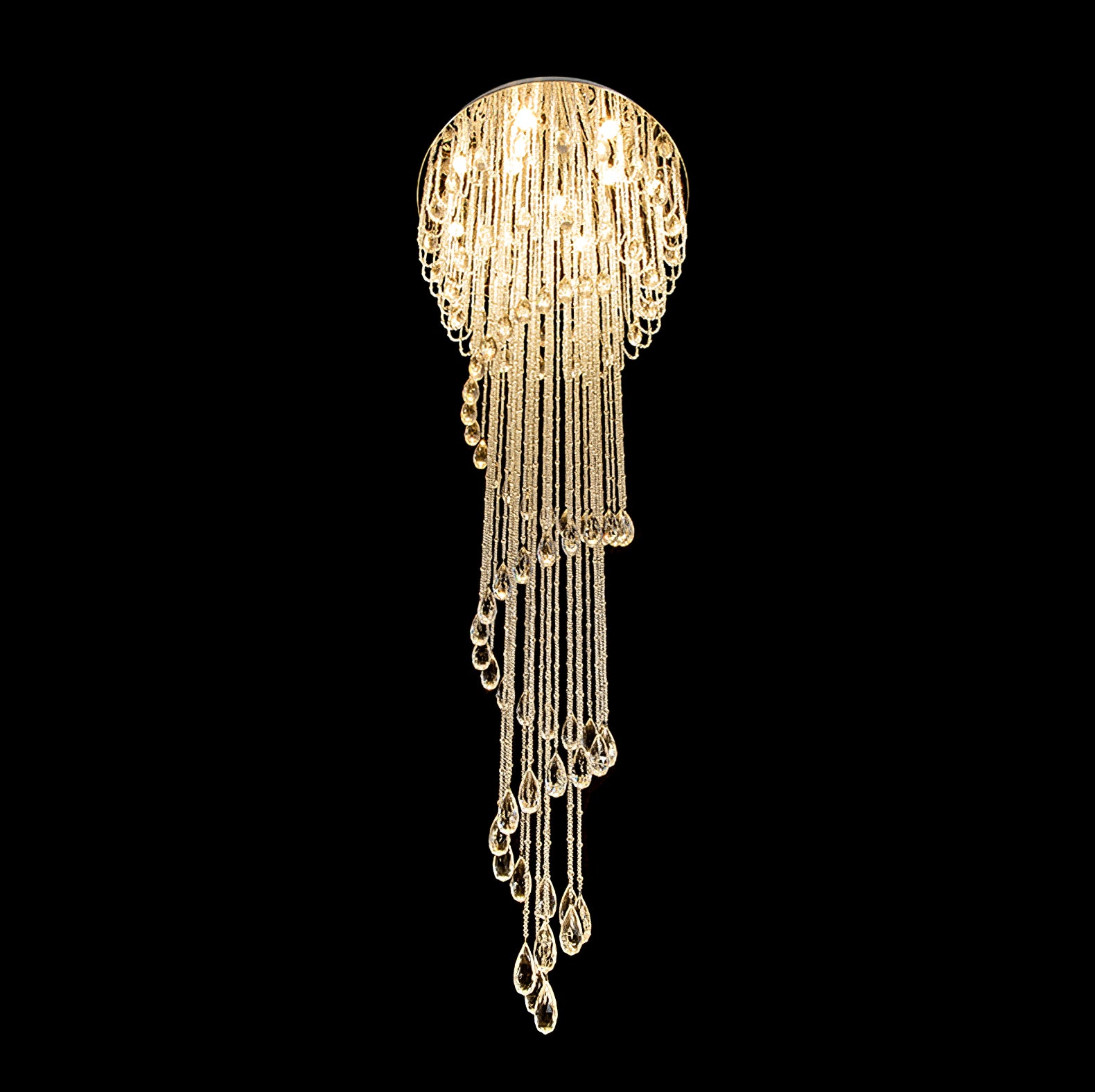 Warm-lit crystal spiral on black from another angle, with scalloped upper rows and faceted teardrops descending to the bottom