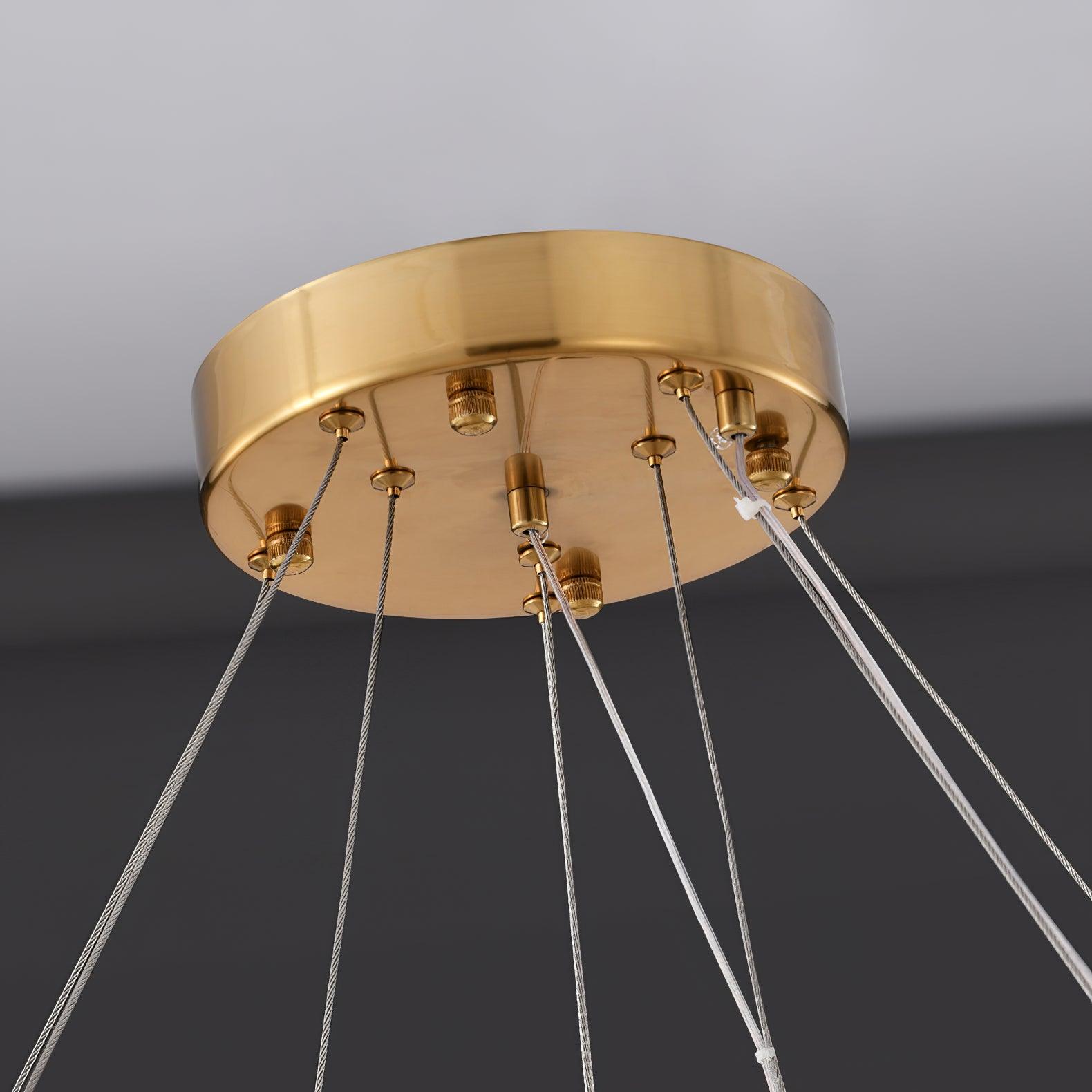 Close underside of gold-tone round canopy with cable grippers, thin support wires and paired clear wires with white ties