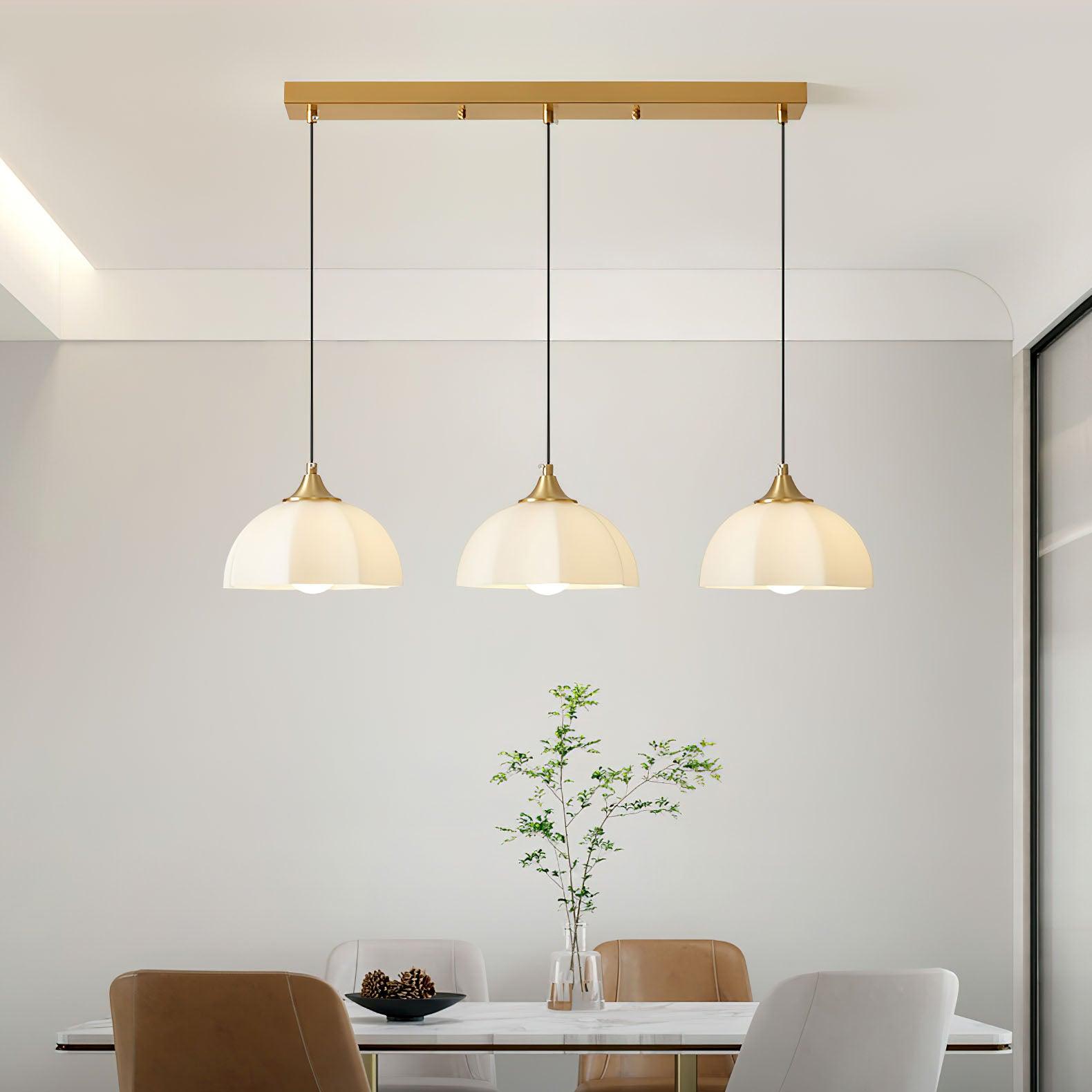 Three white glass pendants on straight ceiling bar