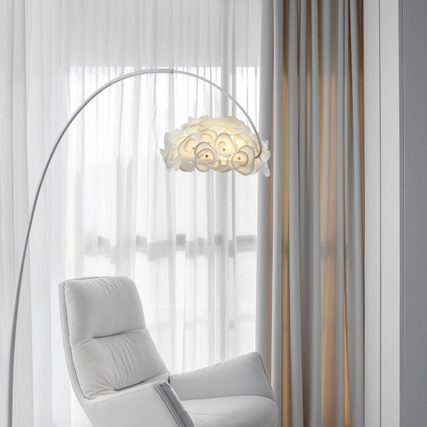 White arched petal lamp above white high-back chair beside sheer and draped curtains, base outside the frame