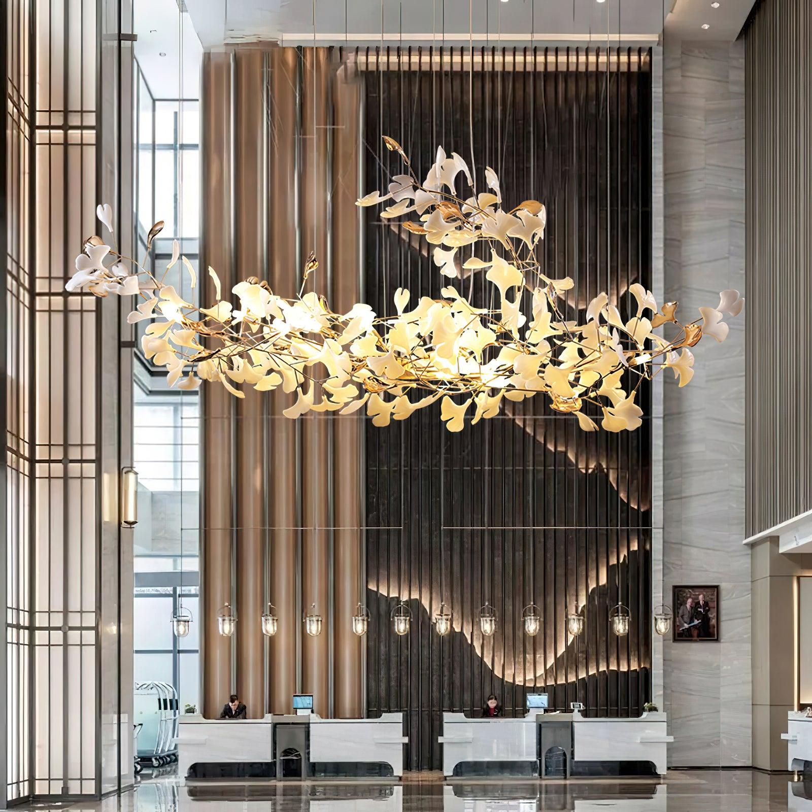 Curved ginkgo leaf chandelier with raised central sweep in tall reception hall beside a gold-toned column