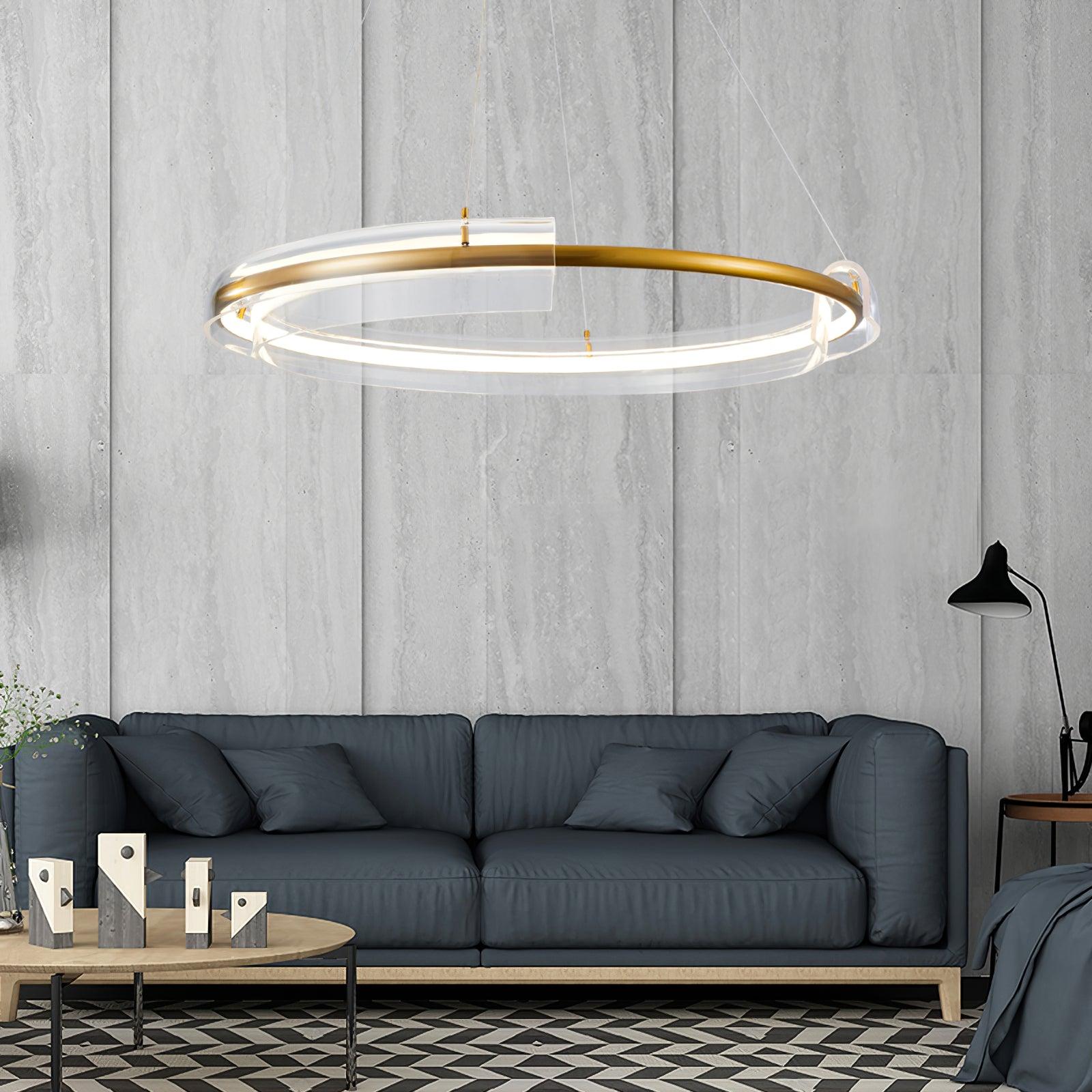 Gold-and-clear ring chandelier above a dark sofa