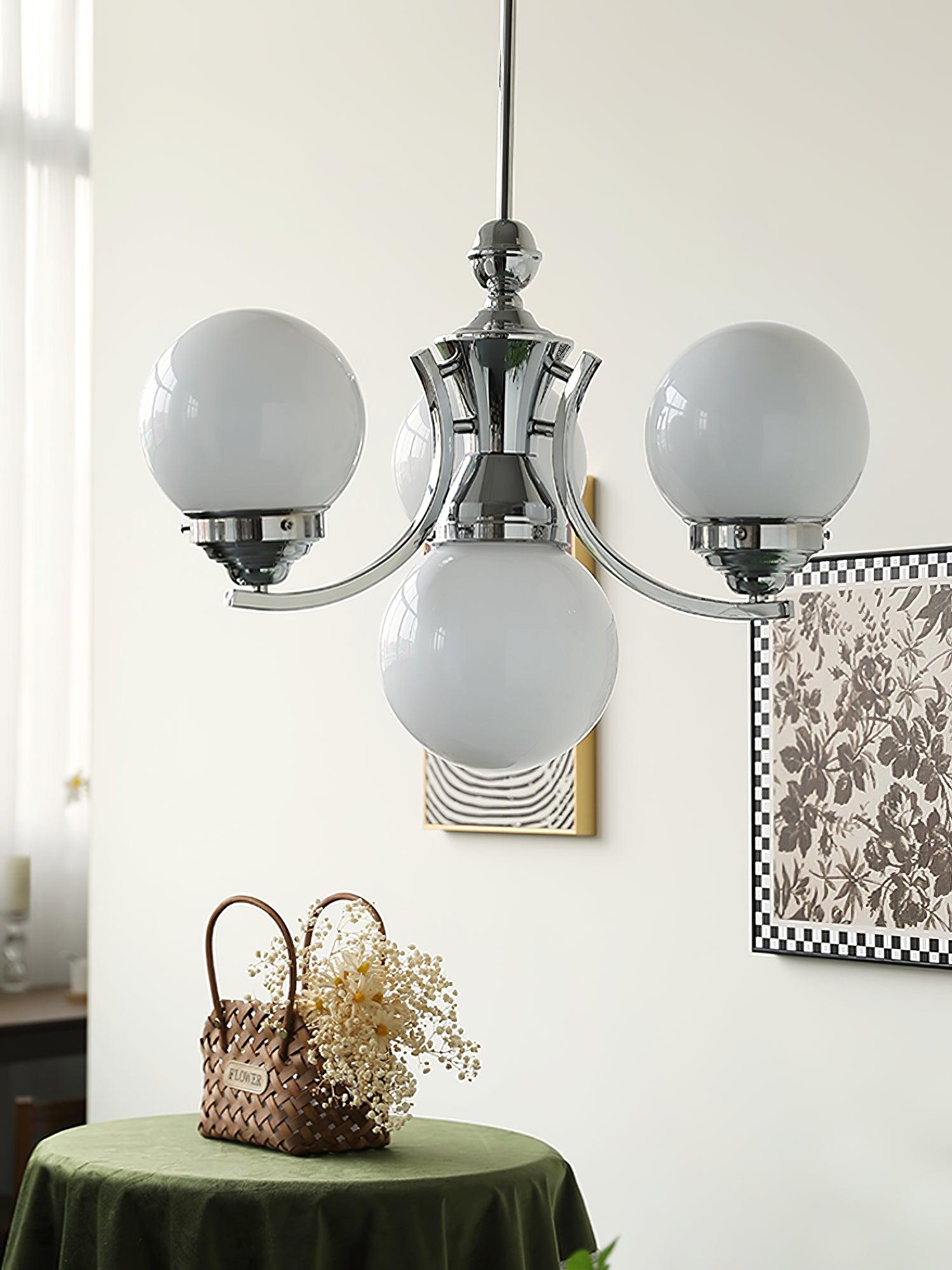 White glass globes on compact rising chrome arms above a green table and woven flower basket