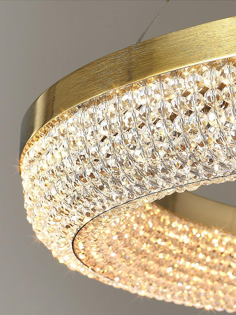 Macro of illuminated clear crystal beads beneath a brushed-looking gold-finish curved rim