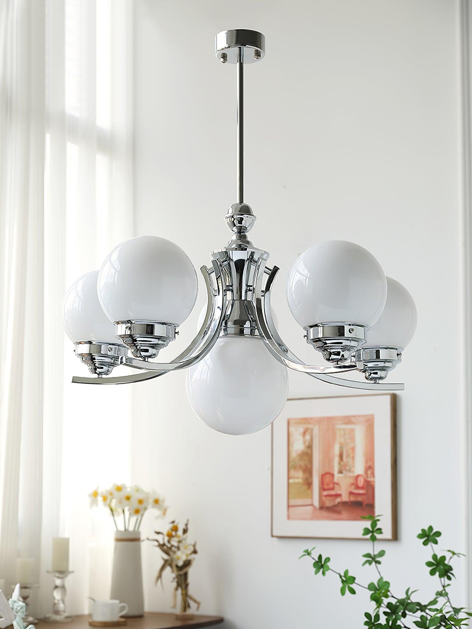 Larger rising-arm Dewdrop with white globes, chrome rod and round canopy near curtains and framed pink art