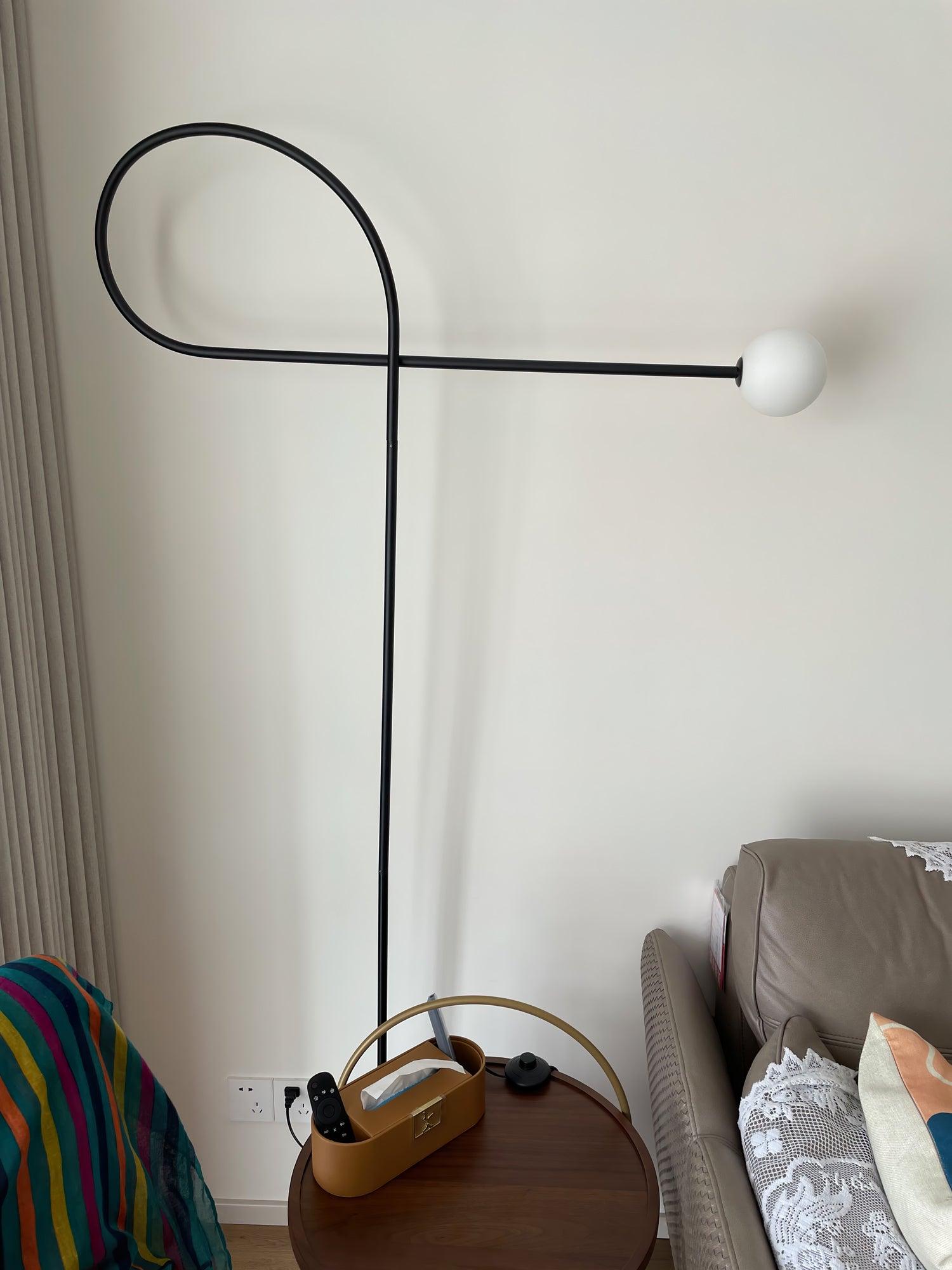 Opposite view of unlit Arcane Orb with its white globe to the right above a round table with an organiser beside a sofa