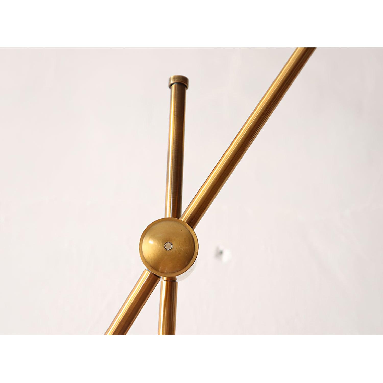 Close-up of a round gold joint joining Kemi’s diagonal arm and vertical pole, with a small central fastener