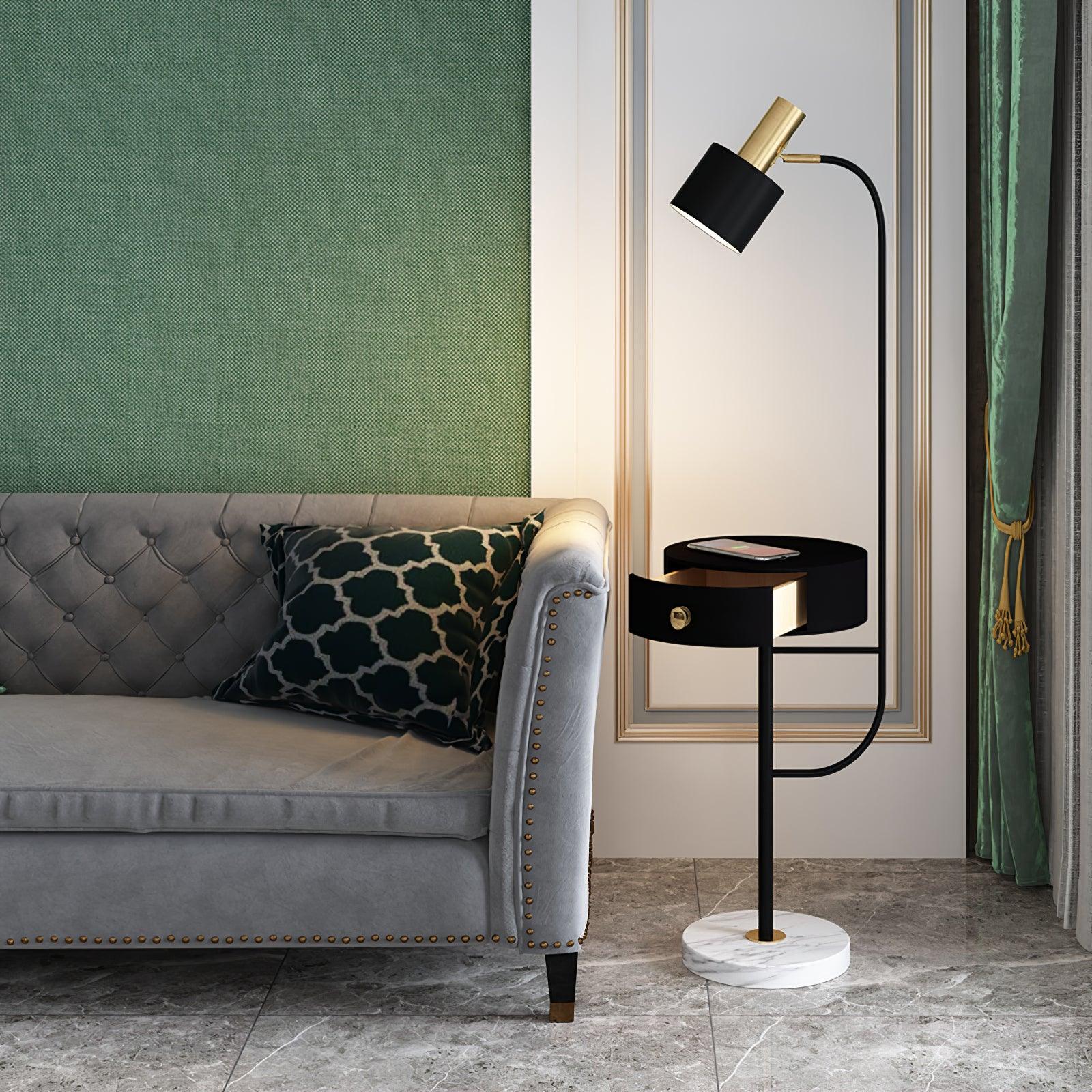 Black Agueda lamp beside gray sofa, black shade and open drawer table, gold fitting and knob, white veined round base