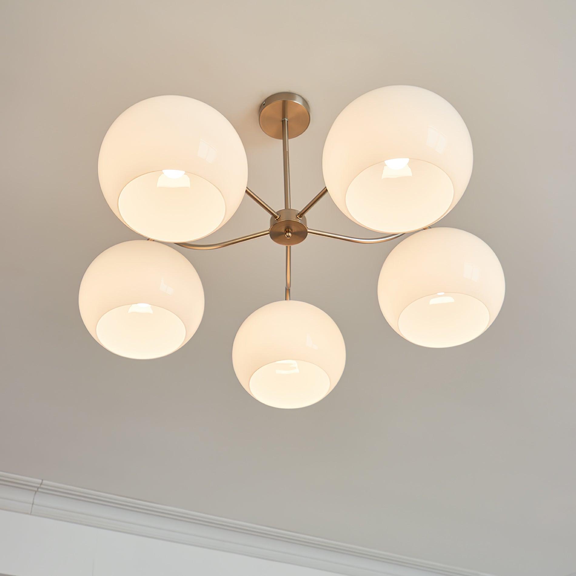 Persimmon chandelier with white glass shades and curved nickel-tone arms