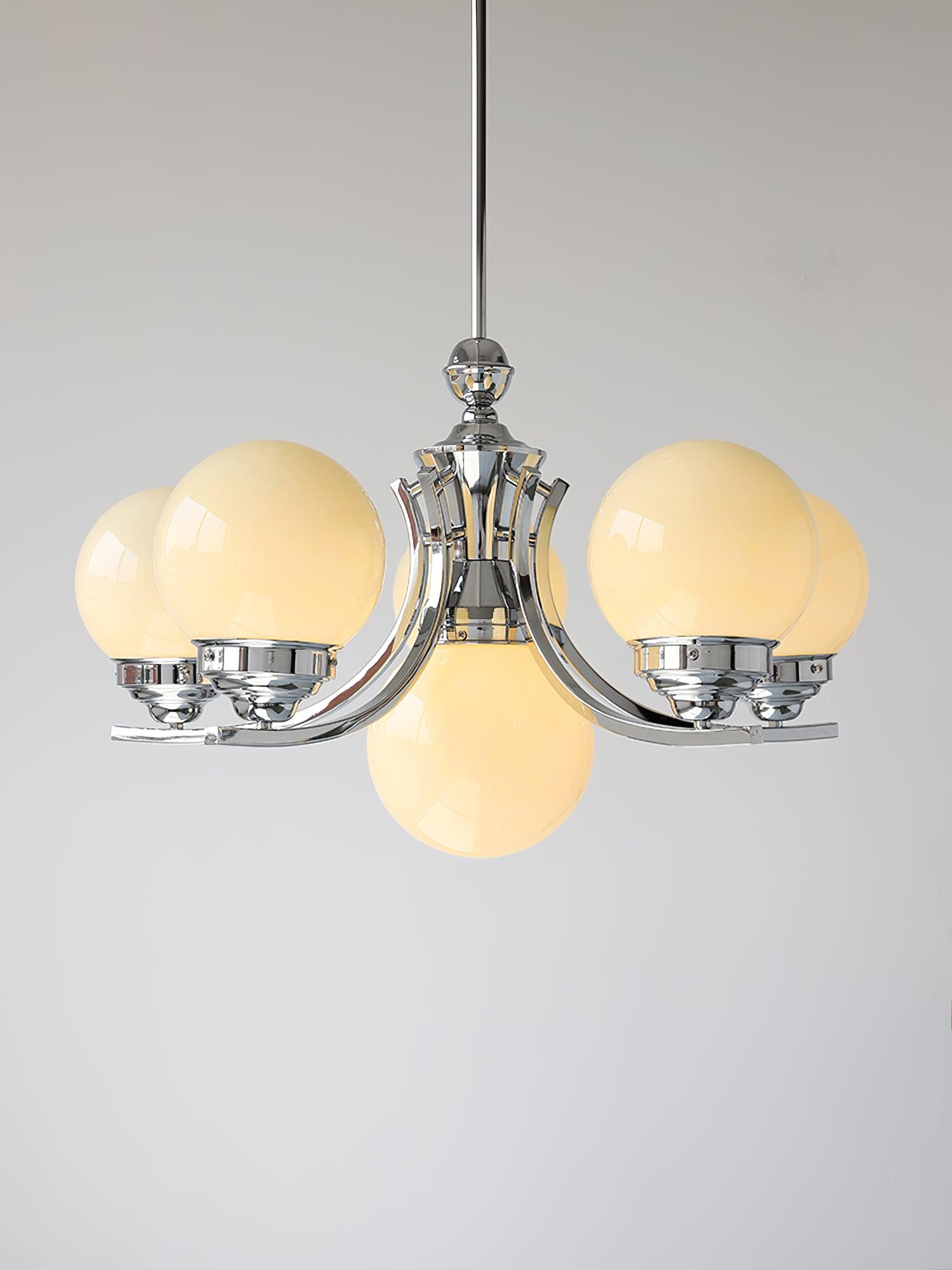 Isolated larger rising-arm Dewdrop with warm-looking glossy globes and a central lower globe against grey