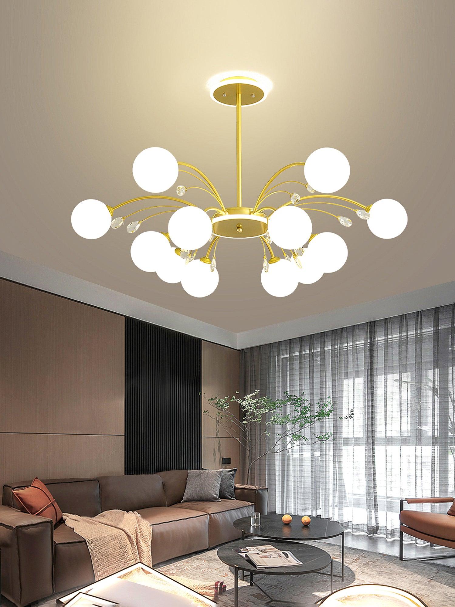 Gold globe and clear-drop chandelier above brown sofa and round dark tables, beside wood panelling and full-height curtains