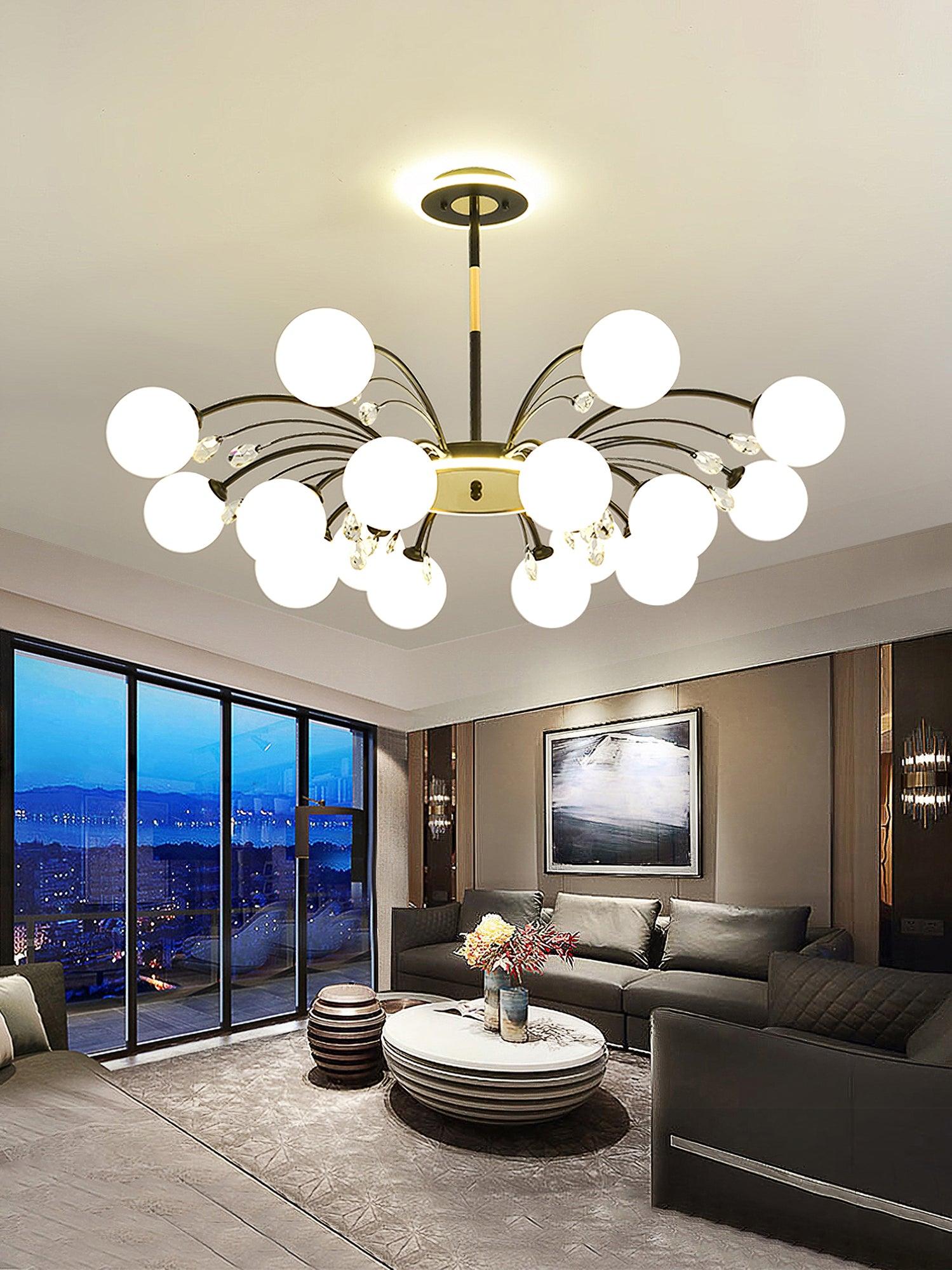 Large Black globe chandelier above grey sectional sofa and stepped white coffee table, with mountain art and city-view glazing