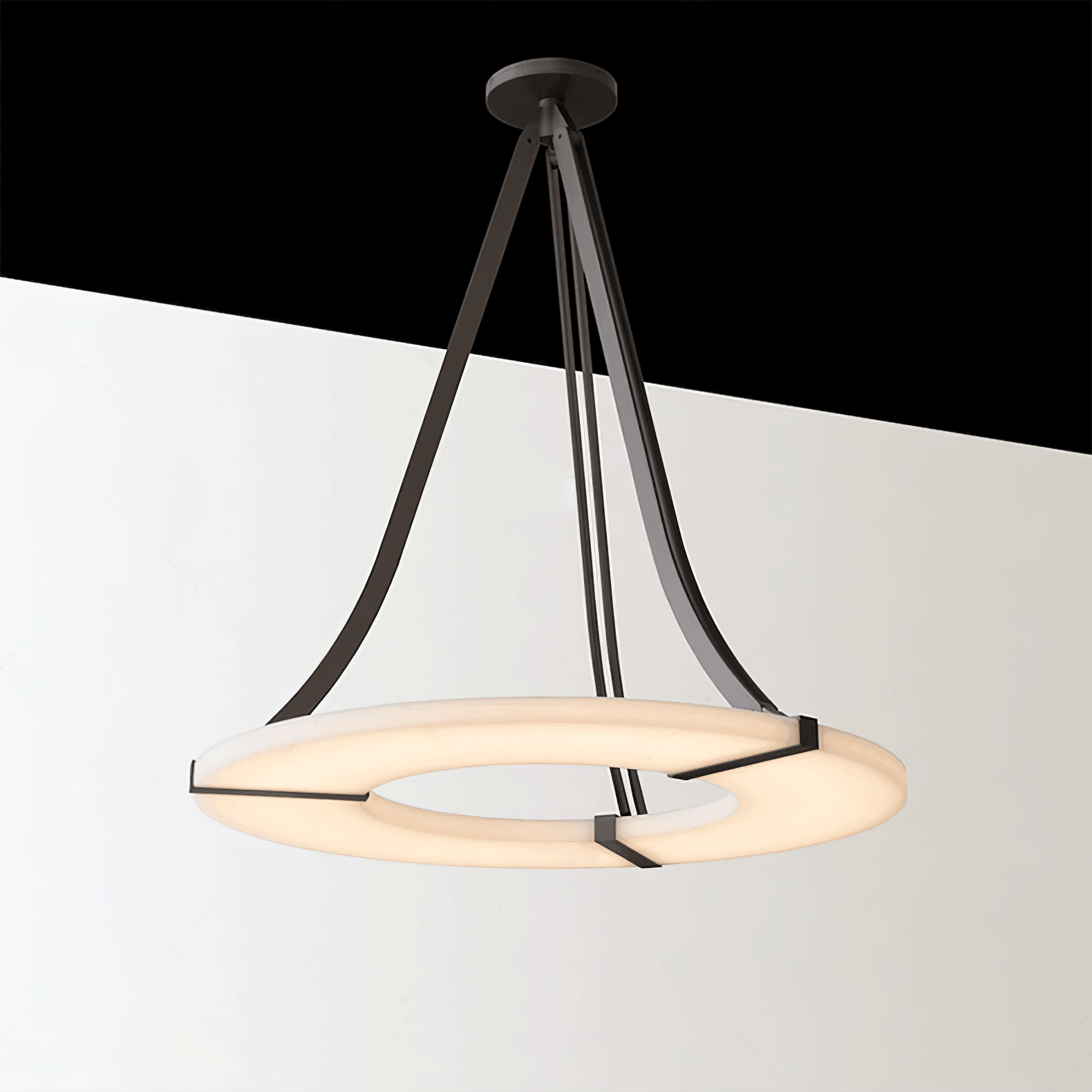 Complete lit halo pendant with black supports against a diagonally sloping pale and dark backdrop
