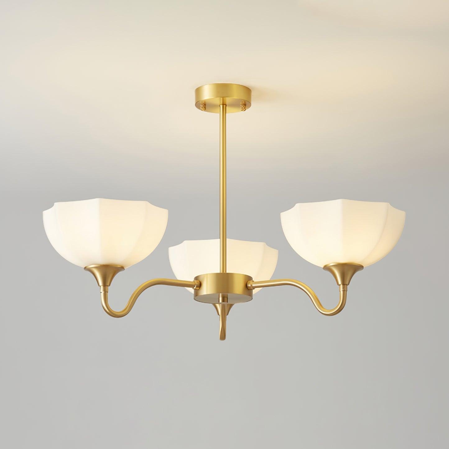 Upward-facing white bowl shades on three-arm brass fixture
