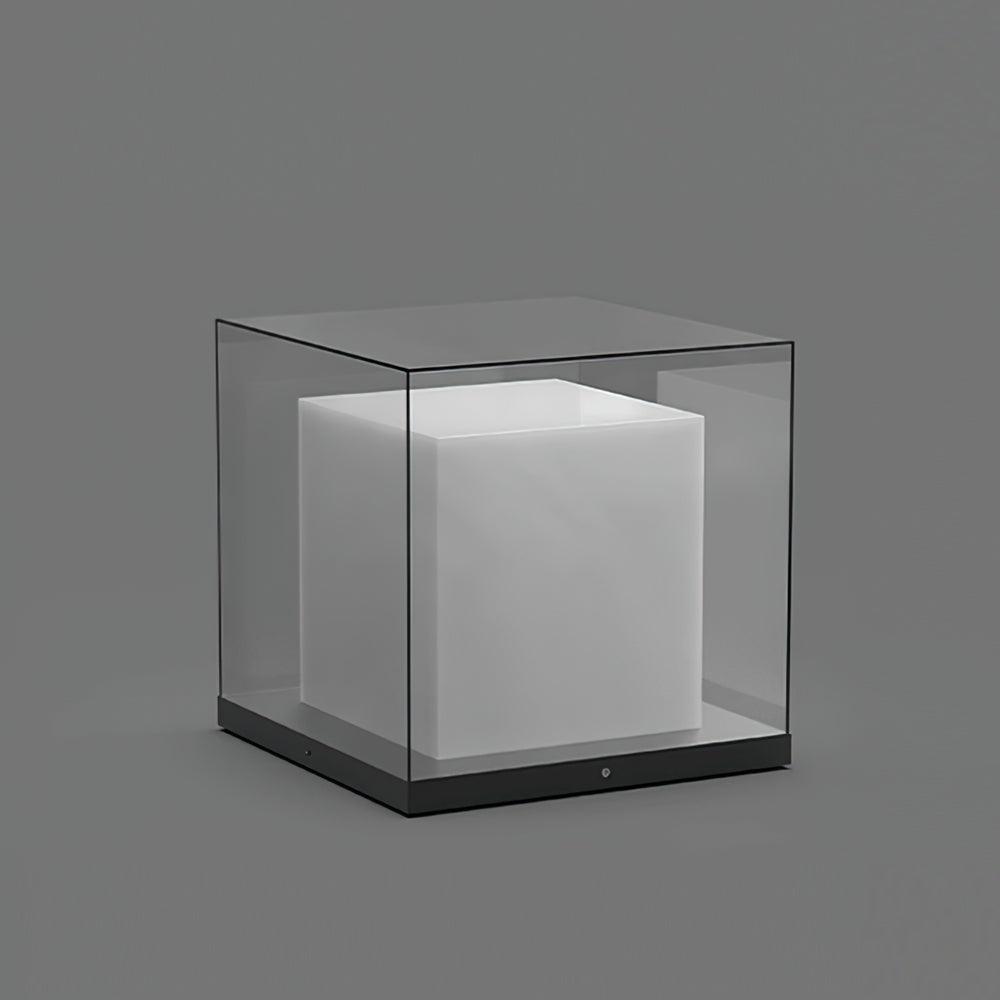 Unlit glass cube enclosure with a central white cube, thin dark edges and flat dark base against grey