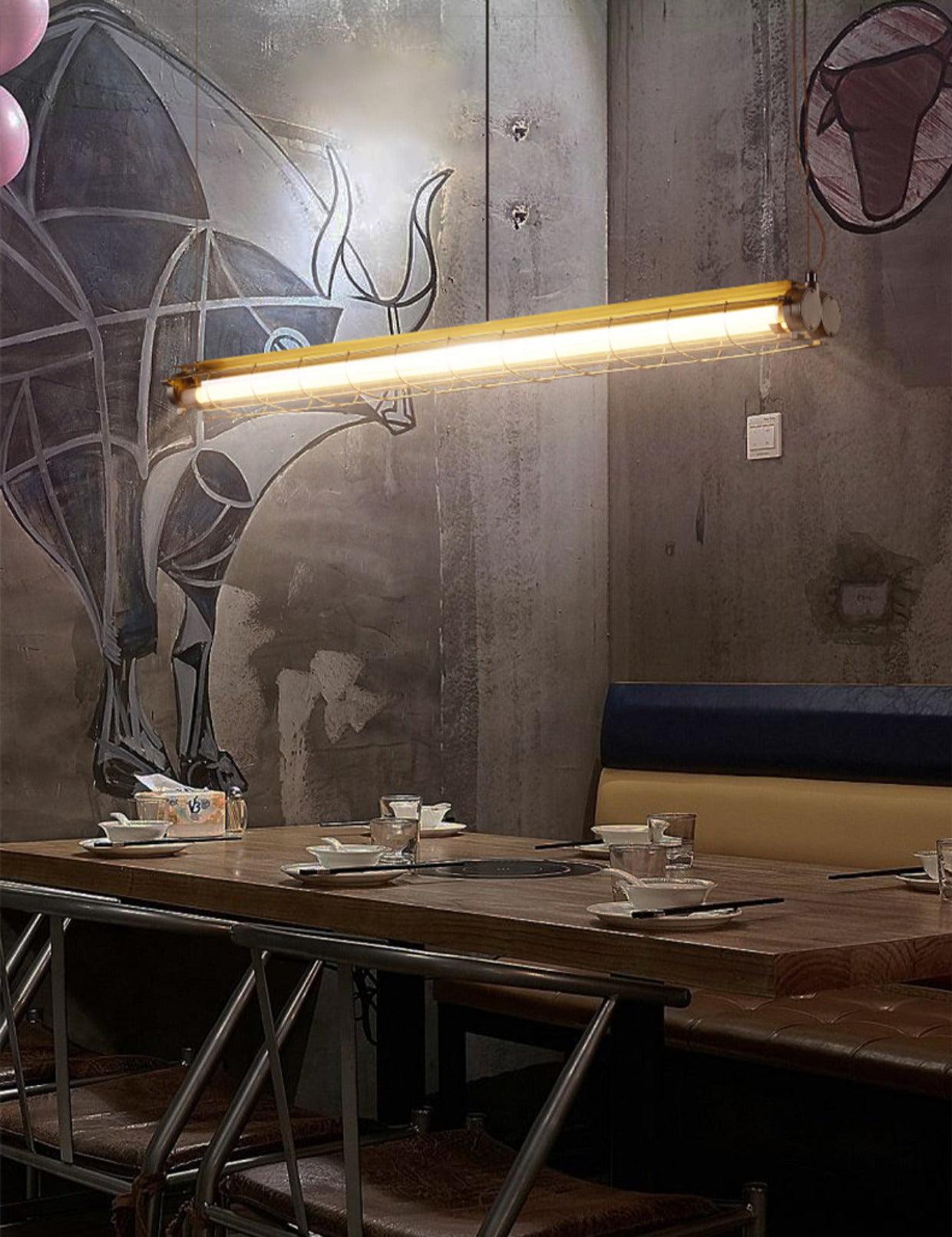 Artisan Glass linear chandelier above a dark wooden table against a mural