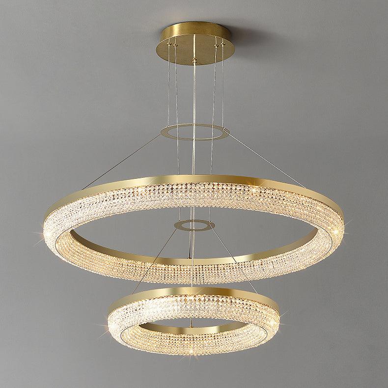 Complete two-ring gold crystal chandelier with large upper and smaller lower ring on grey background
