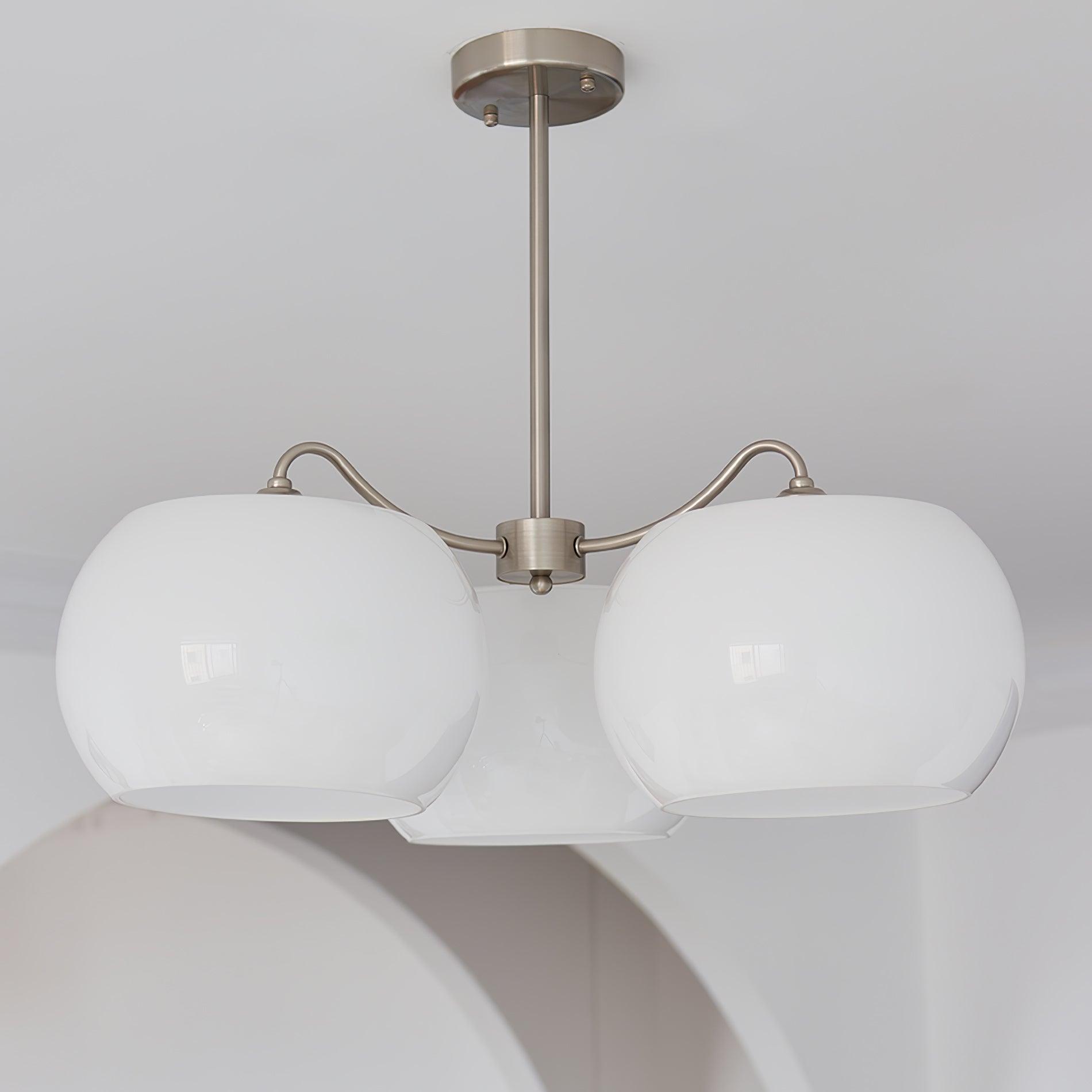 Persimmon chandelier with white glass shades and curved nickel-tone arms