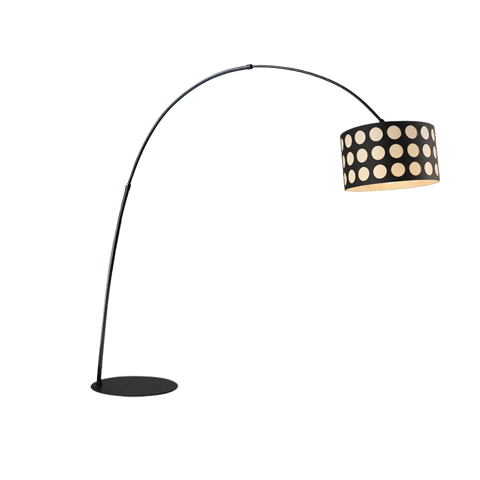 Isolated black arc floor lamp with pale dotted drum shade on right and circular base below curved stem