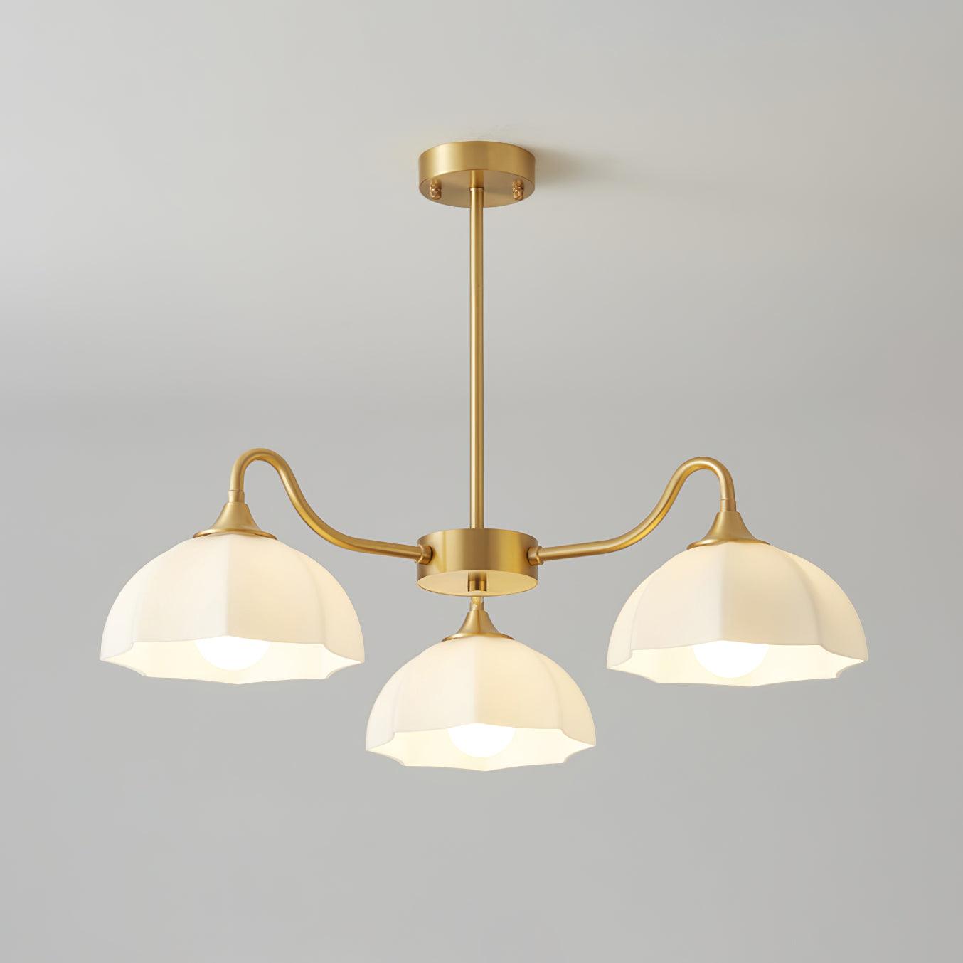 Three down-facing glass shades on brass arms