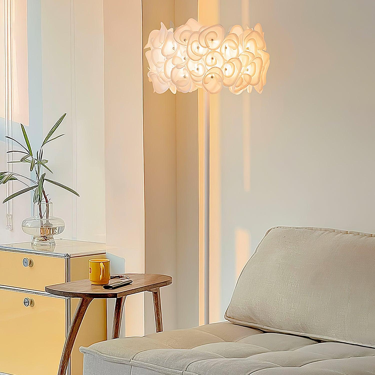 Close upright petal lamp scene with cream chaise, yellow cabinet and plant, wooden side table, yellow mug and glasses