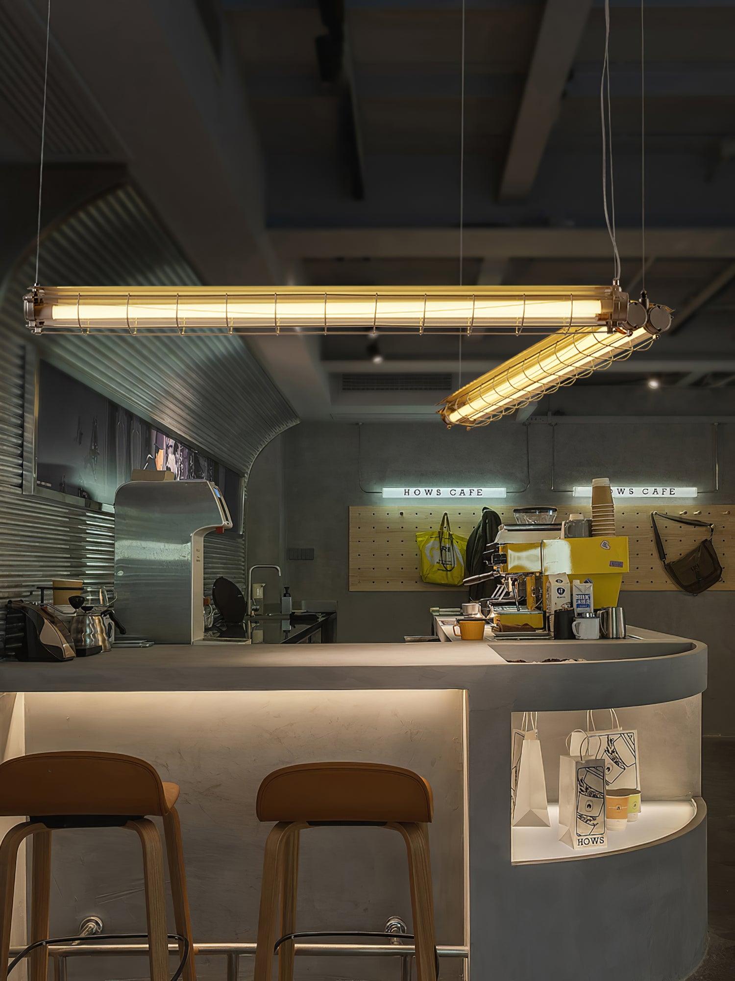 Artisan Glass chandeliers in a cafe with stools, hanging plants and an exposed concrete ceiling