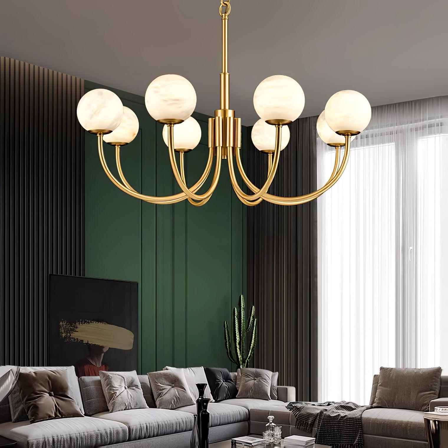 Brass chandelier above sectional sofa near dark wall