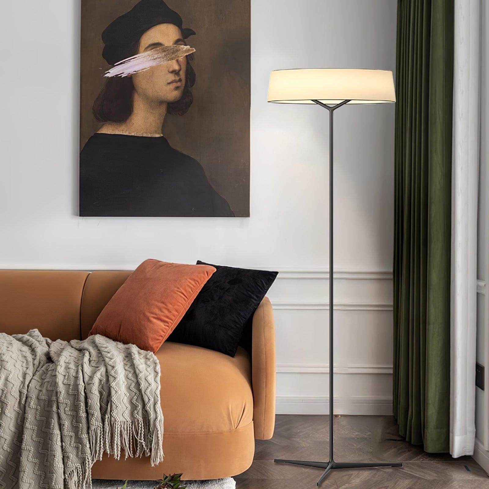 Circular floor lamp beside an orange sofa