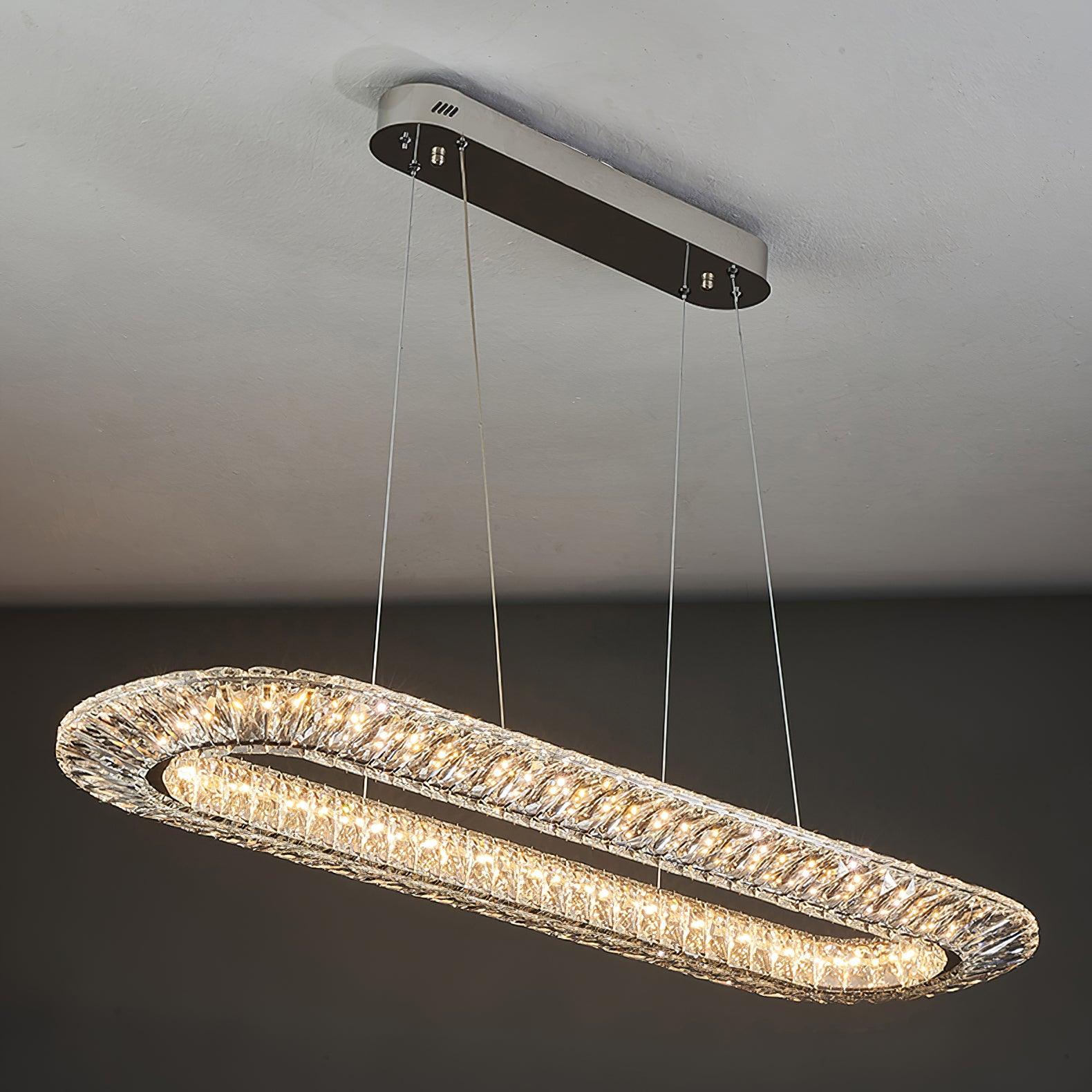 Elongated crystal chandelier with rounded ends suspended from a long ceiling plate