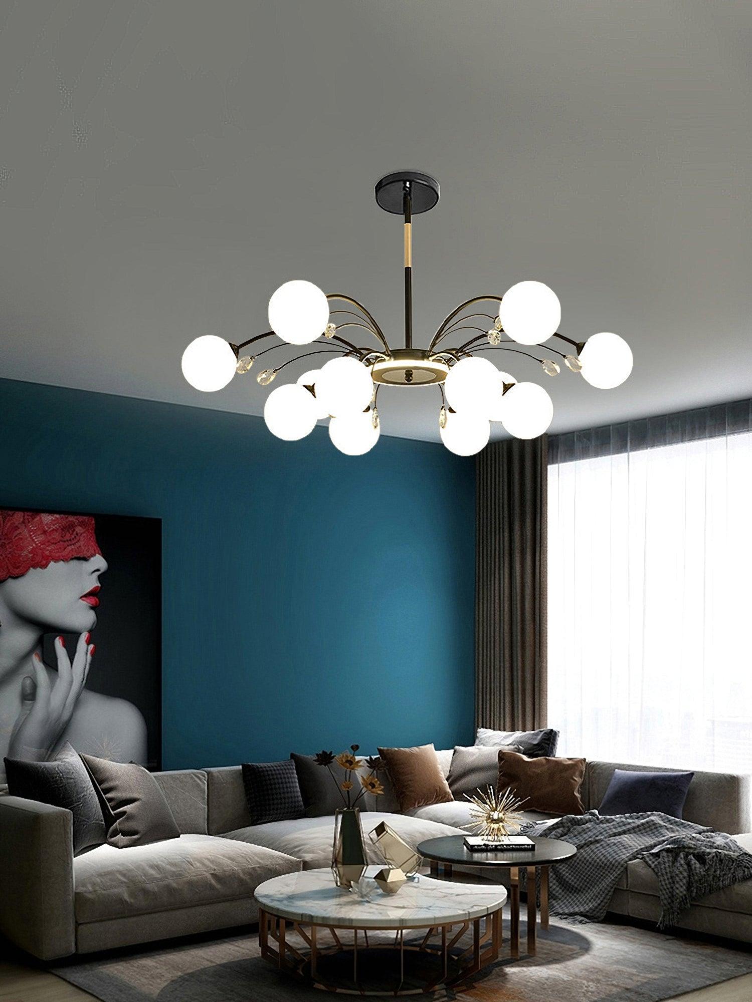 Black globe and drop chandelier over grey sofa and round tables, against teal wall with large face artwork and curtain