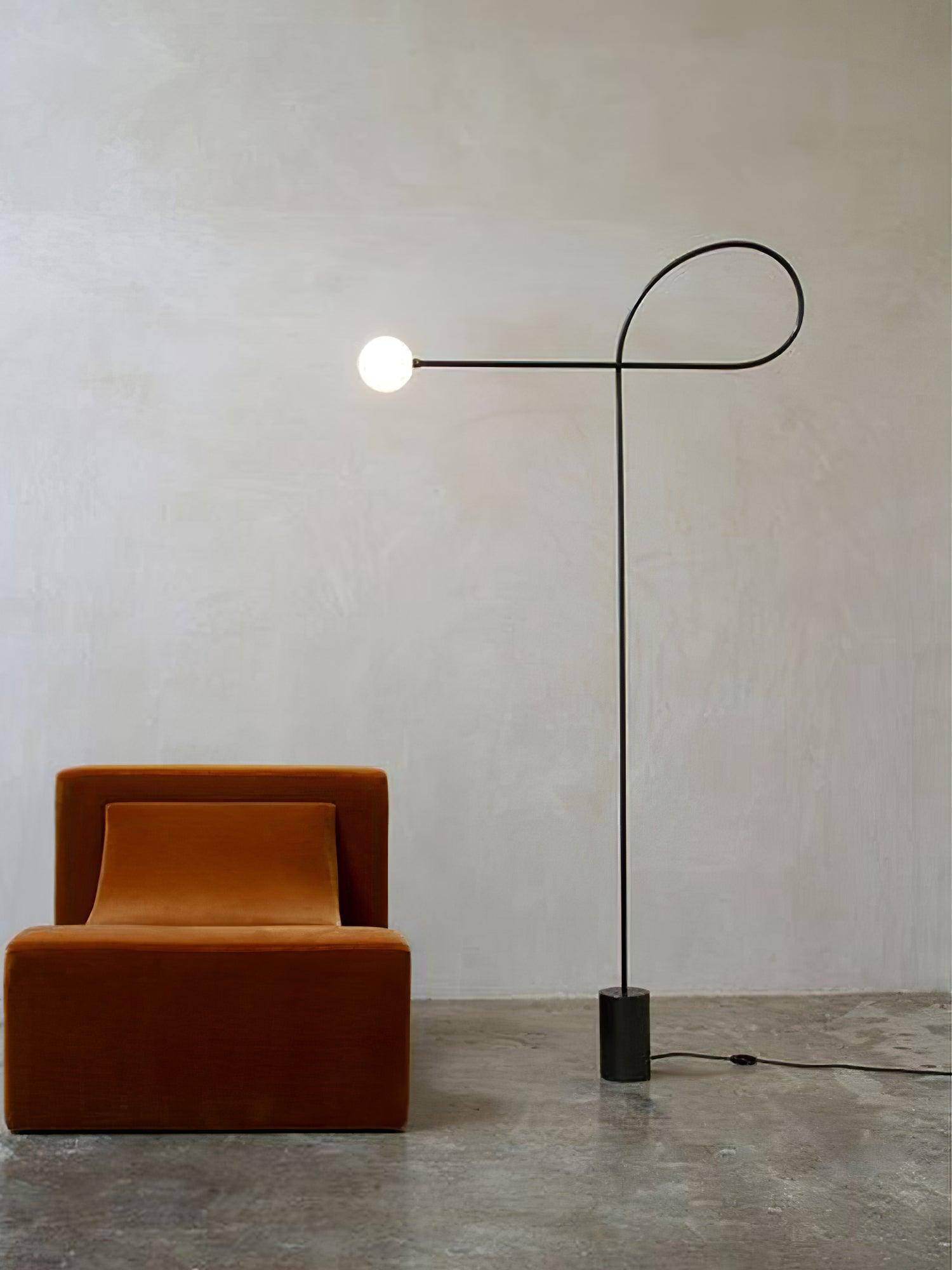 Tall view of lit Arcane Orb beside an ochre armchair, with its cylindrical black base, floor cable and inline switch