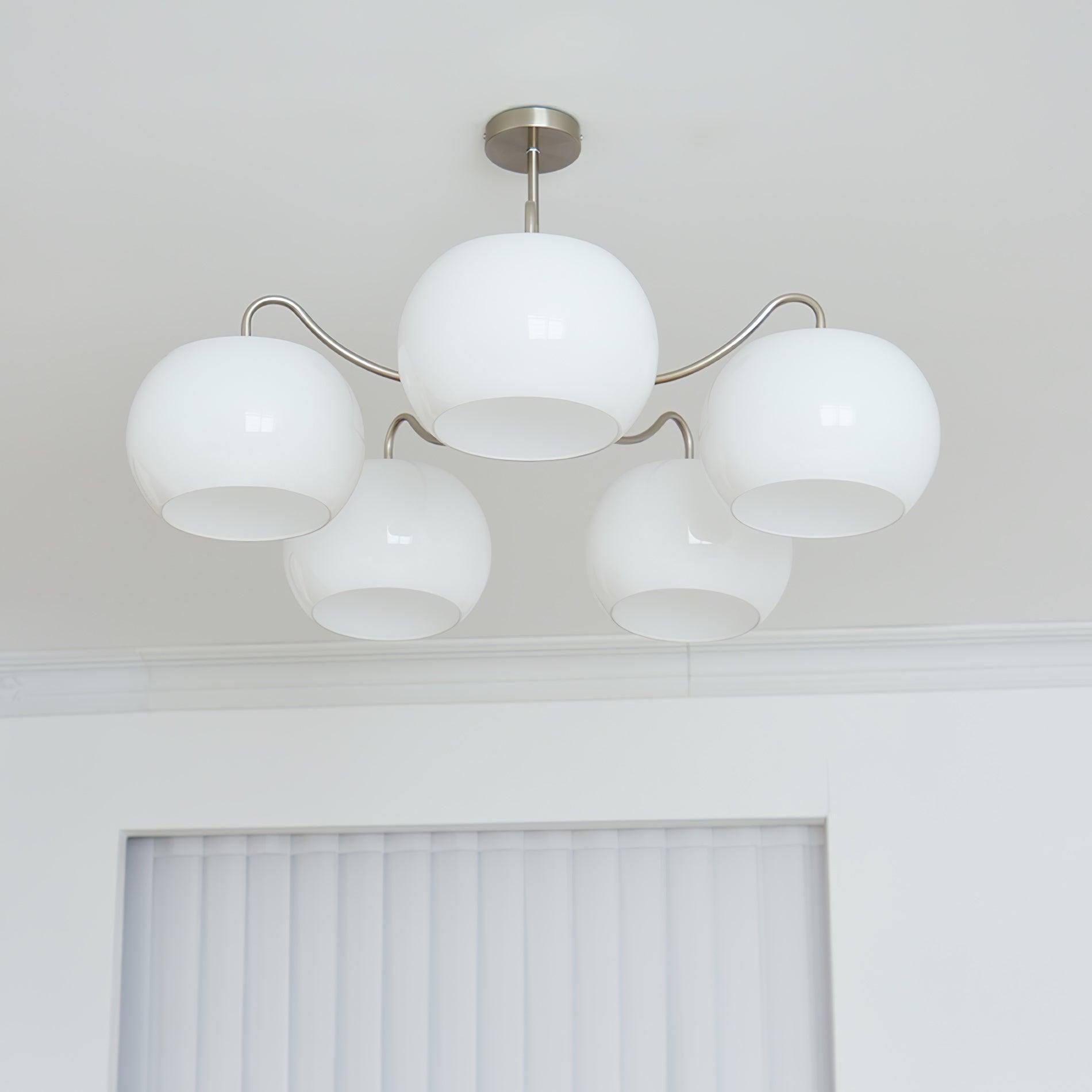 Persimmon chandelier with white glass shades and curved nickel-tone arms