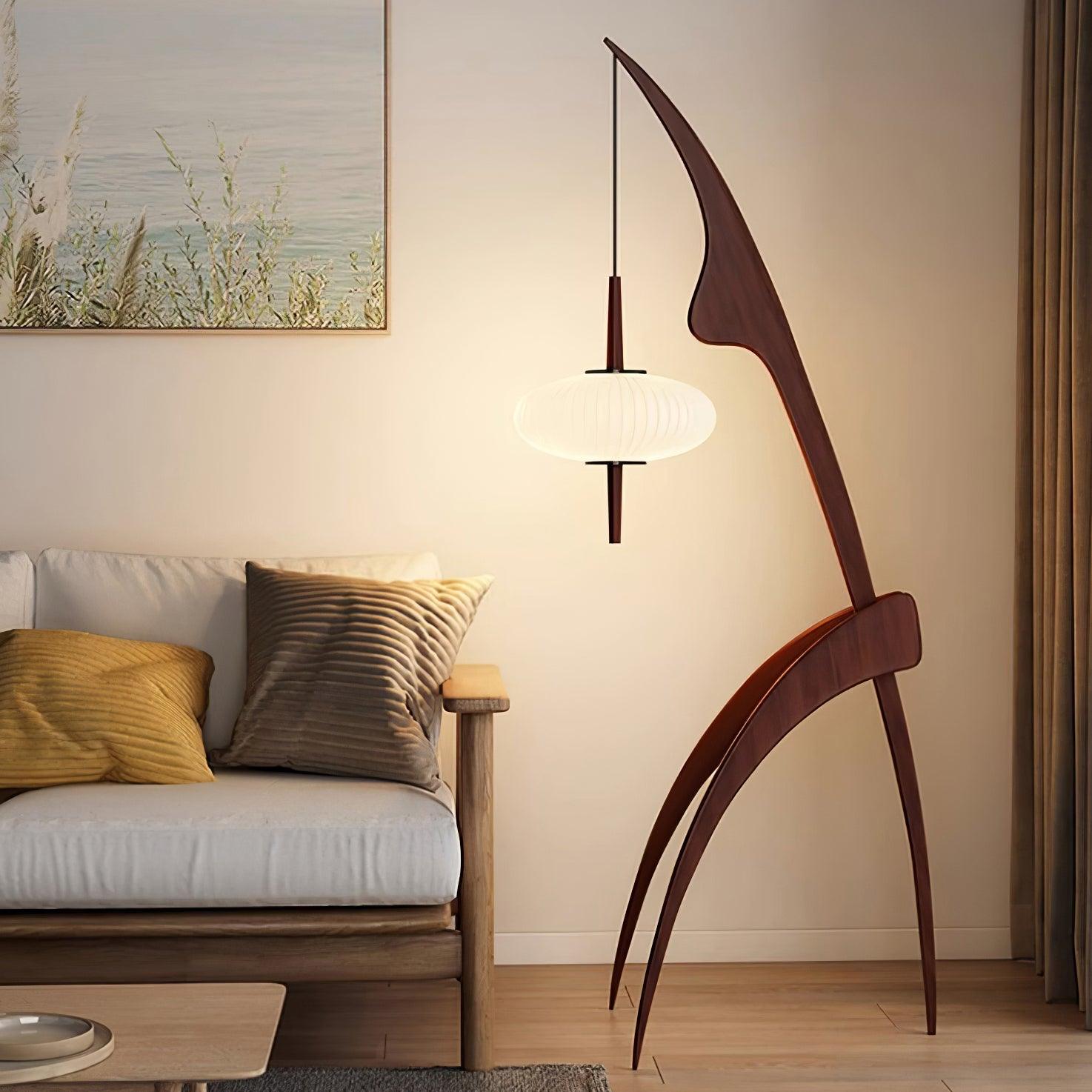 Walnut-colour Mantis floor lamp beside a pale sofa