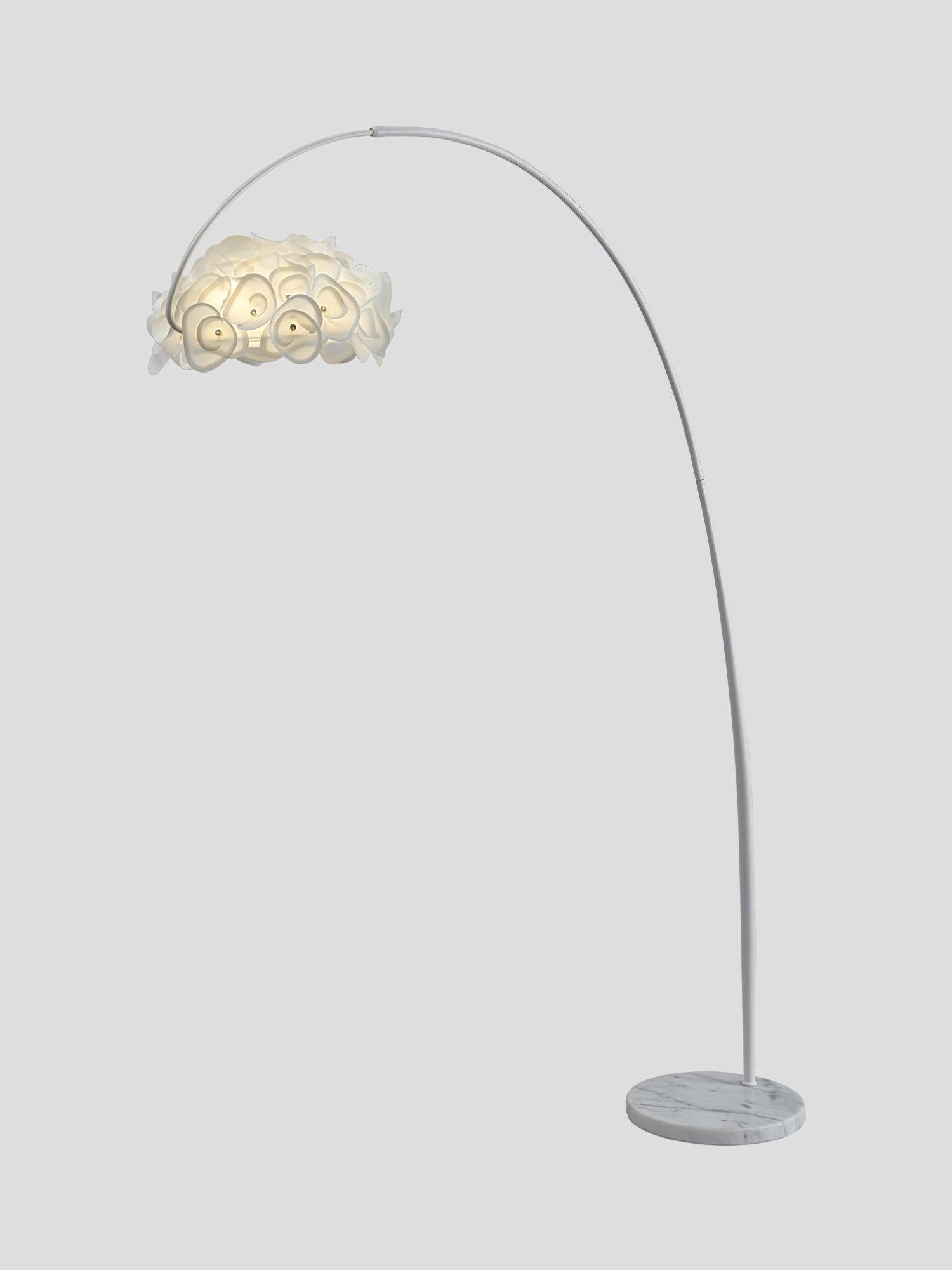 Isolated arched Hydrangea floor lamp on gray, white curved pole, lit petal shade and gray-veined round base