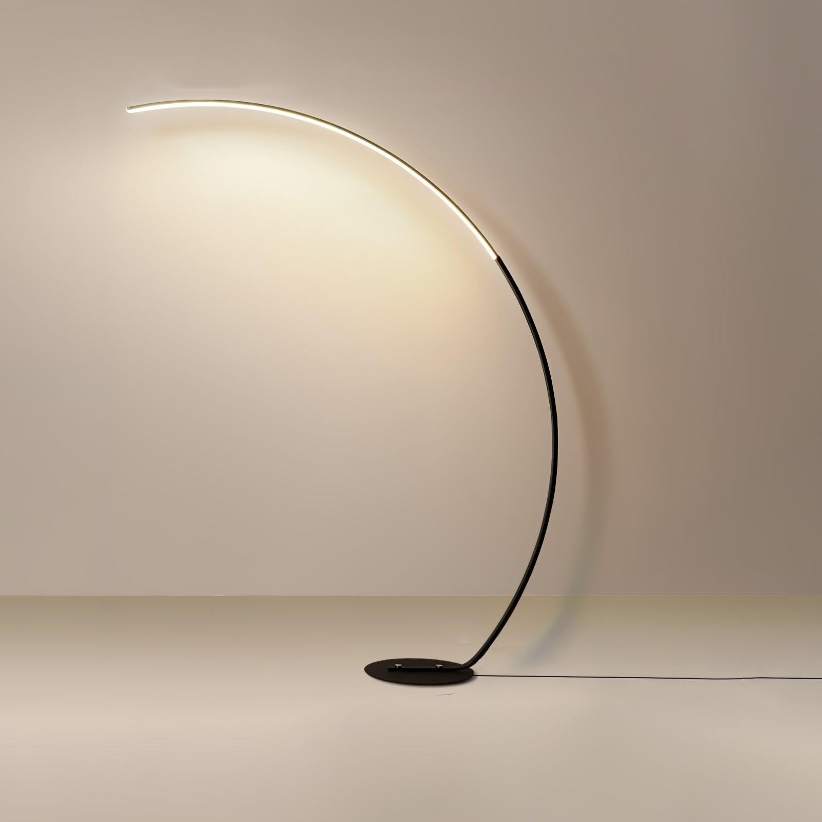 Full Black Arc floor lamp on plain beige background, with low plate base and cable extending along floor