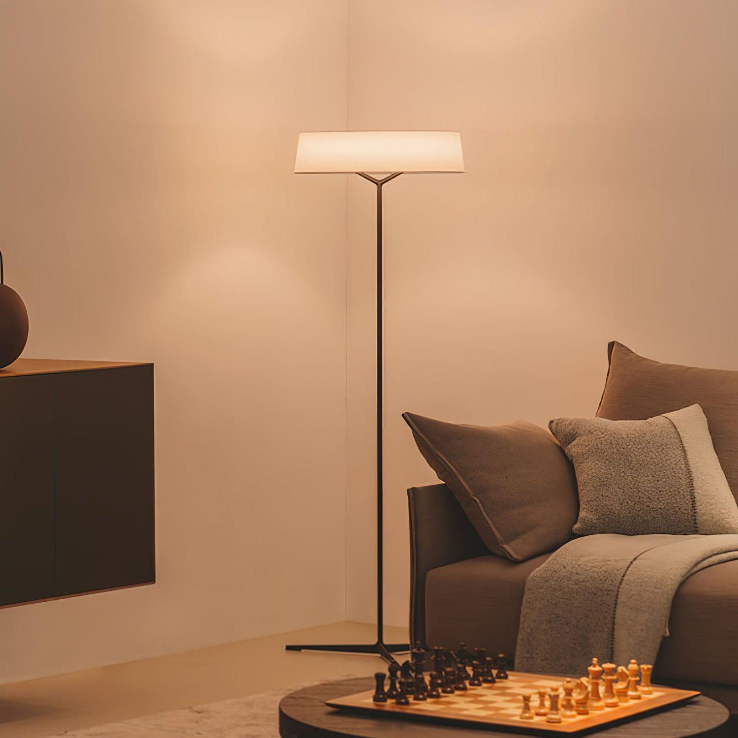 Circular floor lamp beside a sofa and chess table