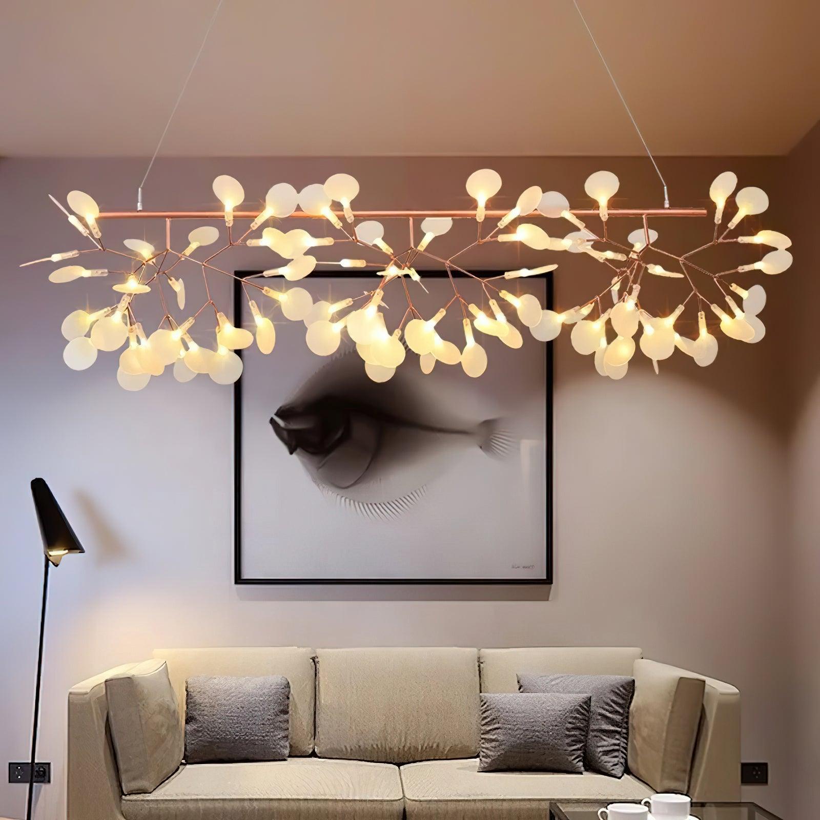 Rose-gold-colour branching chandelier above cream sofa and dark cushions, with eye artwork and black floor lamp