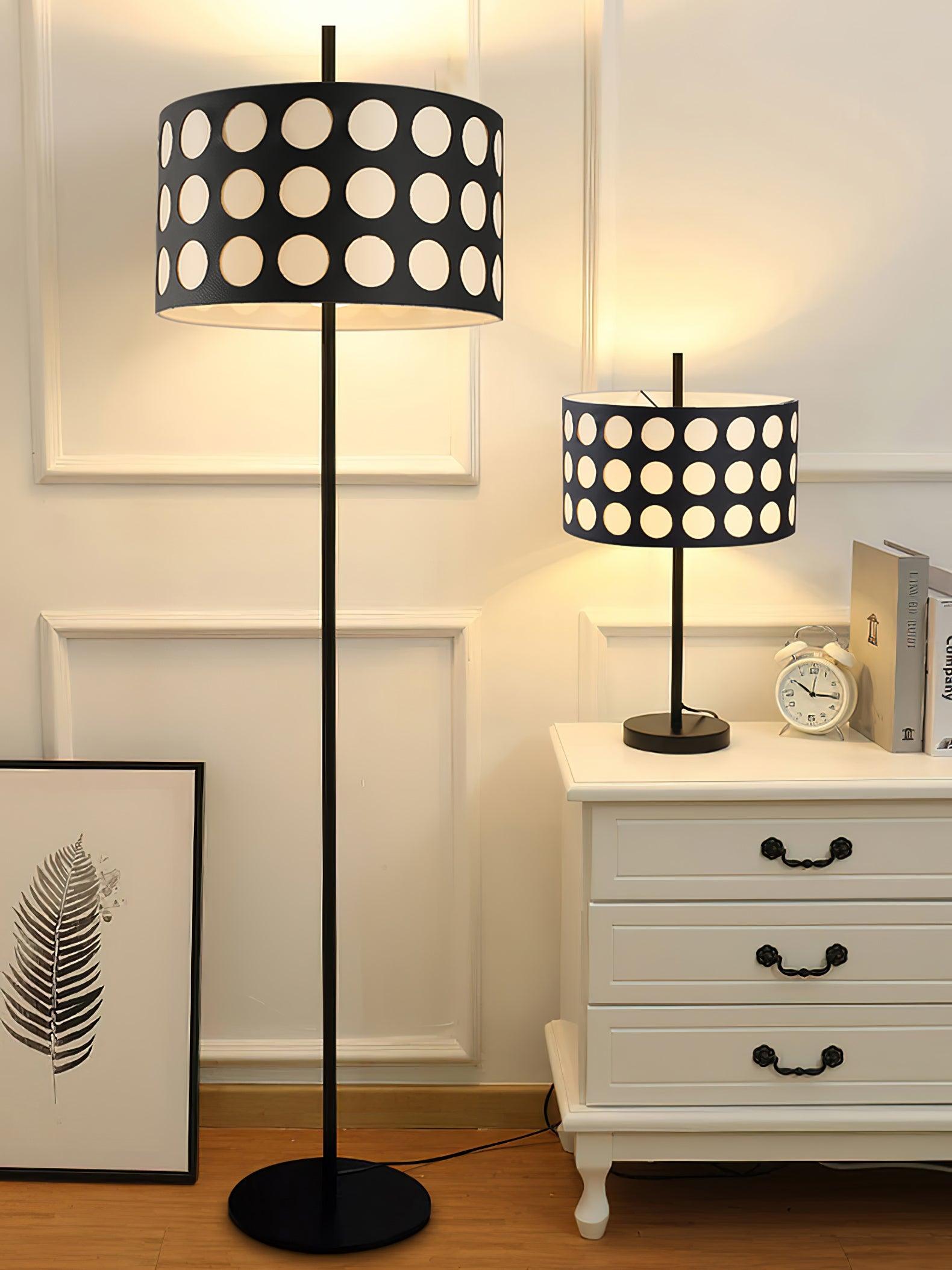 Straight dotted-shade floor lamp beside matching table lamp on white dresser, foliage print and alarm clock