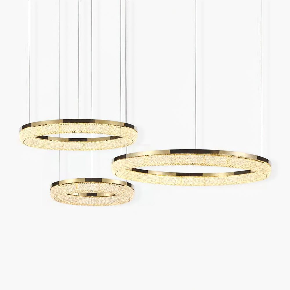 Three offset gold crystal rings with a warm-looking glow against a light background