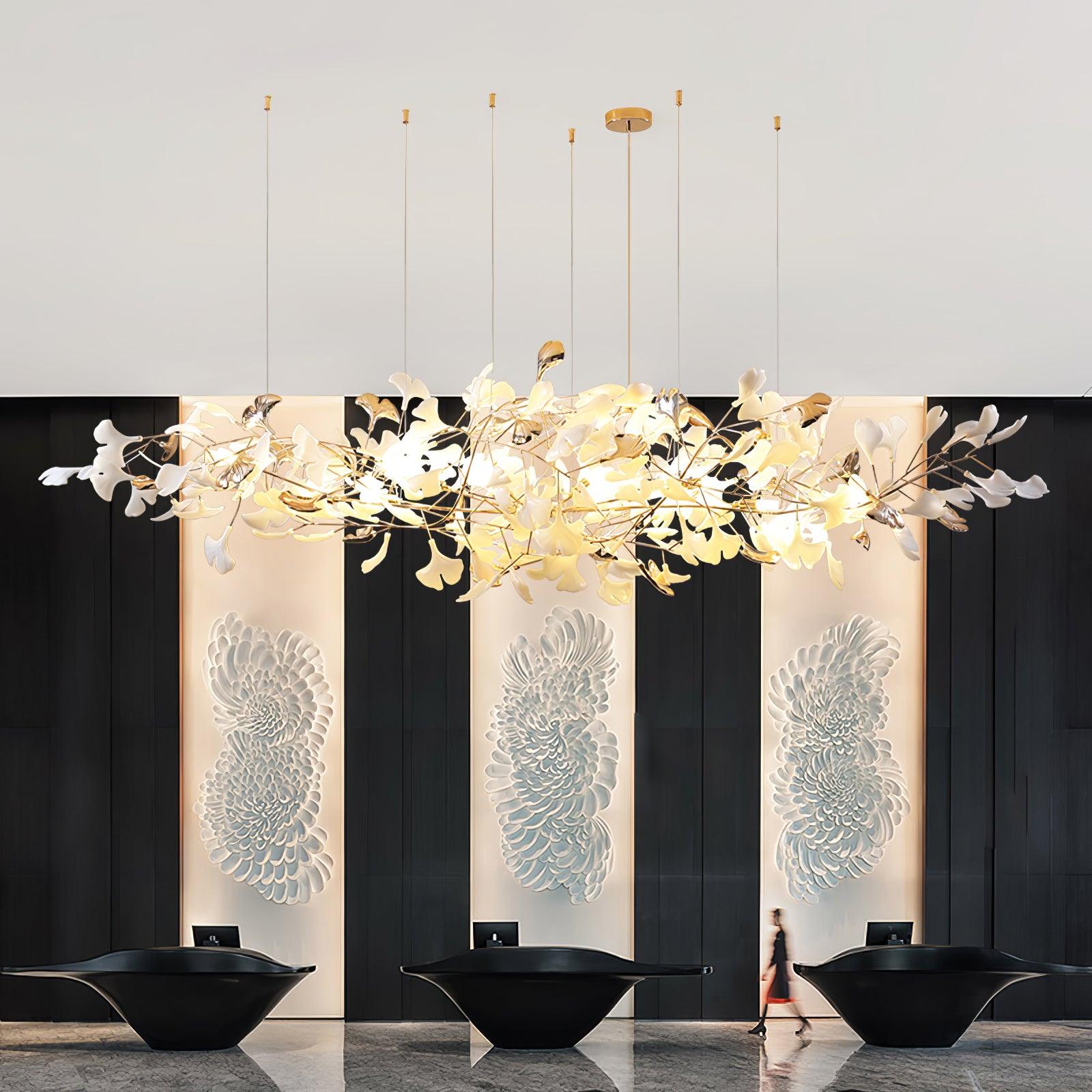 Broad glowing leaf chandelier above three black reception desks with illuminated white petal wall reliefs behind