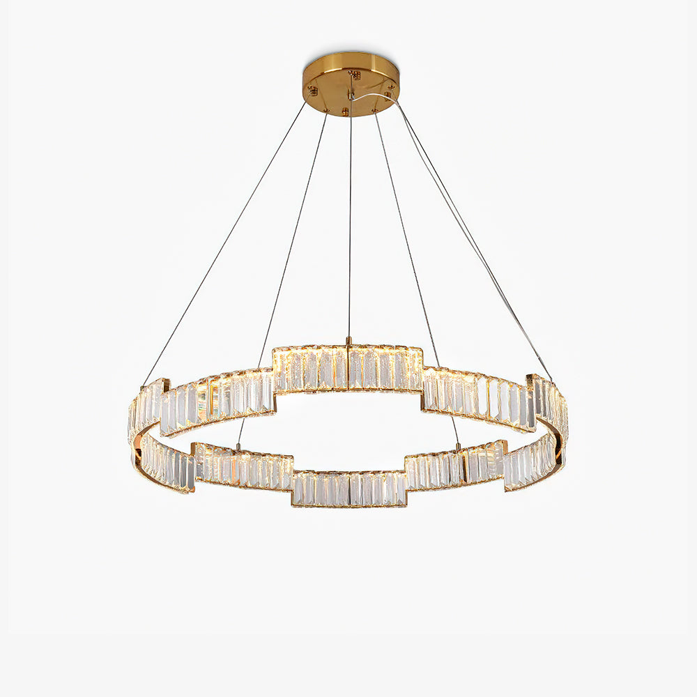 Isolated lit stepped ring chandelier with clear faceted panels, gold-tone rails, thin wires and round canopy on white